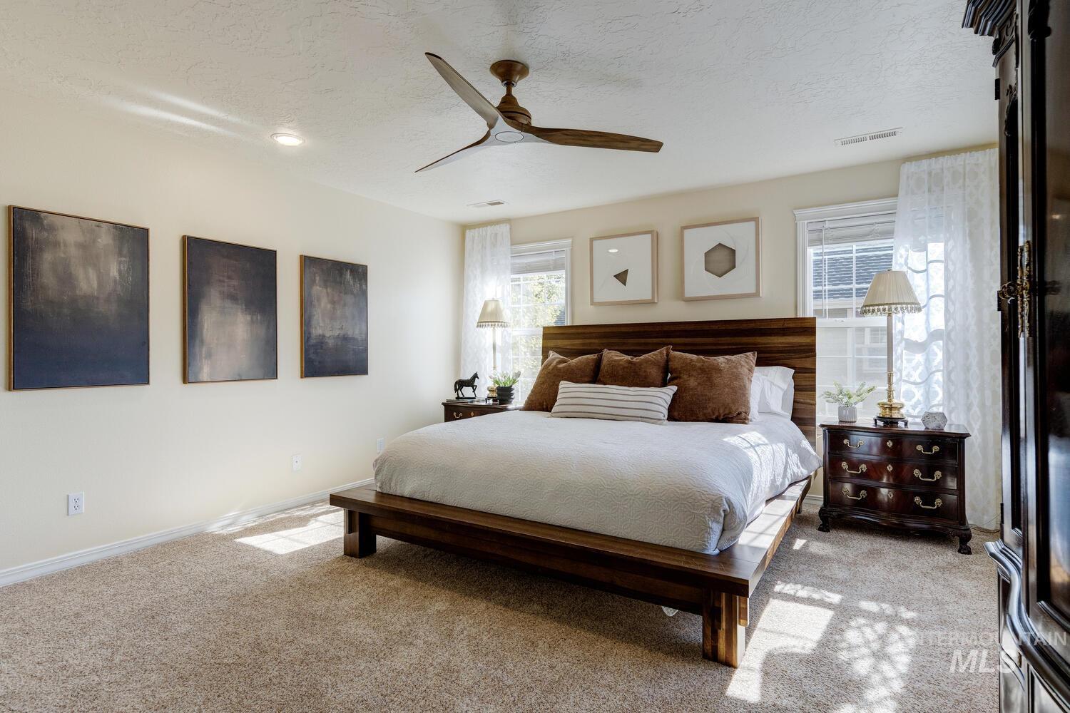 Bedroom with light carpet, a textured ceiling, and a ceiling fan