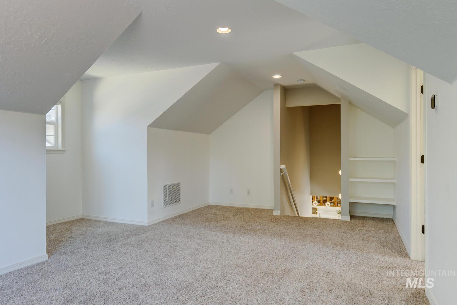 Additional living space featuring light colored carpet, recessed lighting, and lofted ceiling