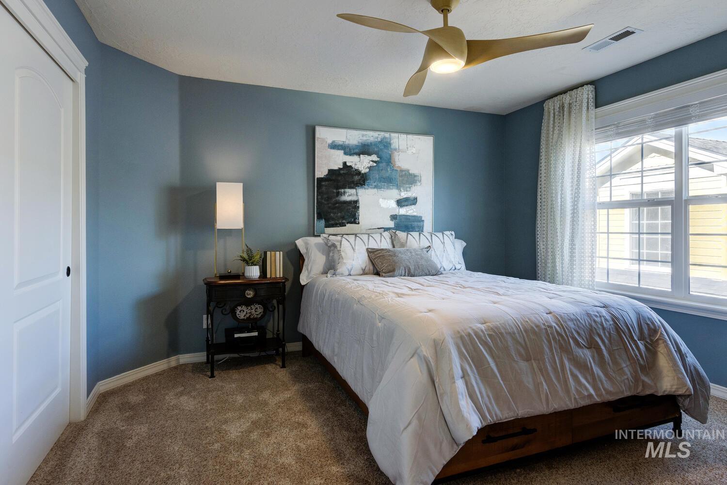 Bedroom featuring carpet floors, a ceiling fan, and a closet