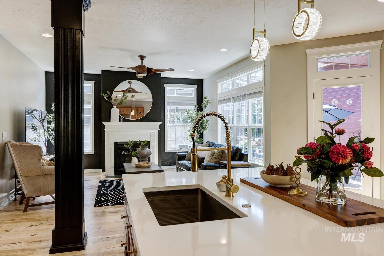 Kitchen featuring light wood-style floors, hanging light fixtures, light stone counters, recessed lighting, and open floor plan