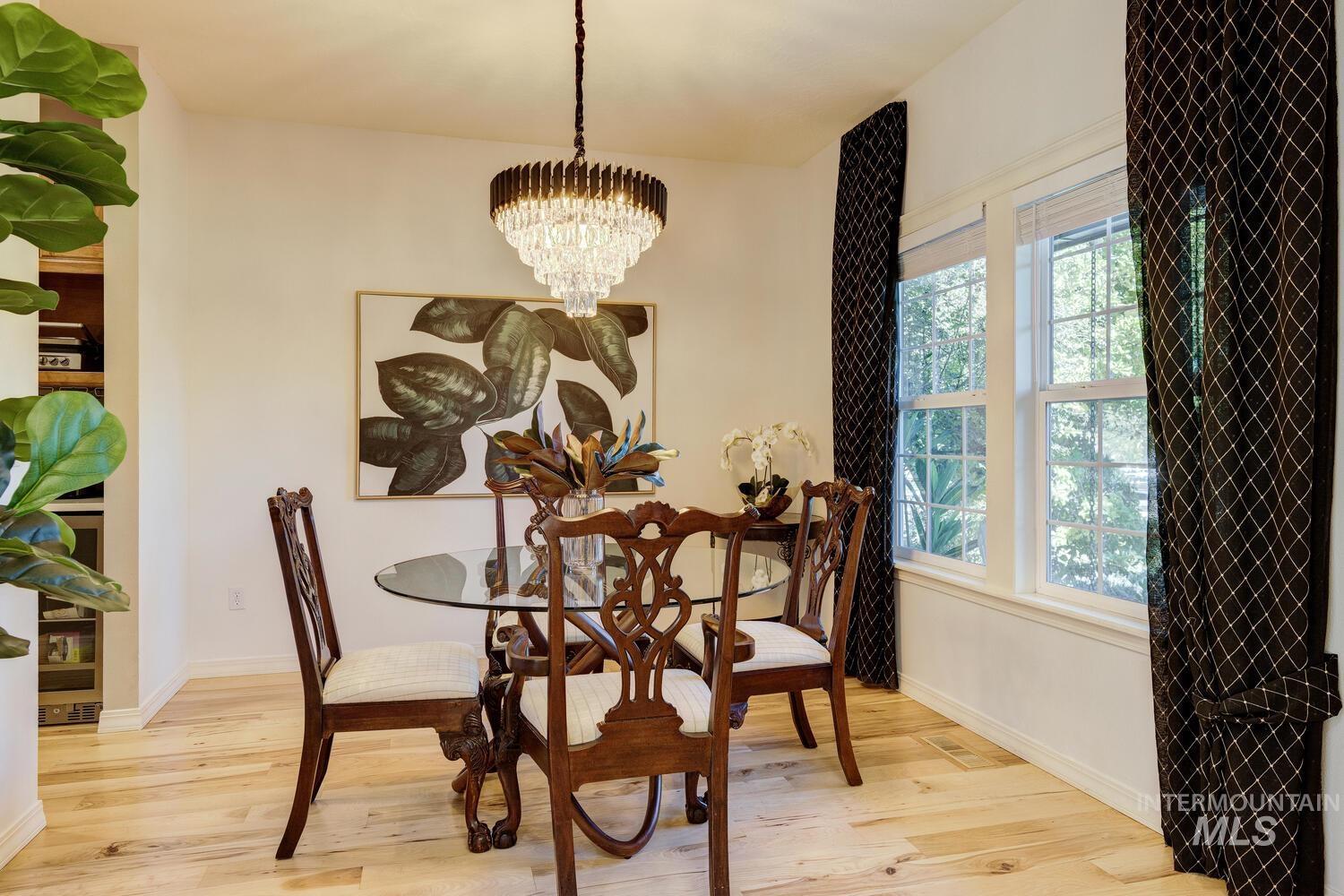 Dining area with light wood-type flooring and a chandelier
