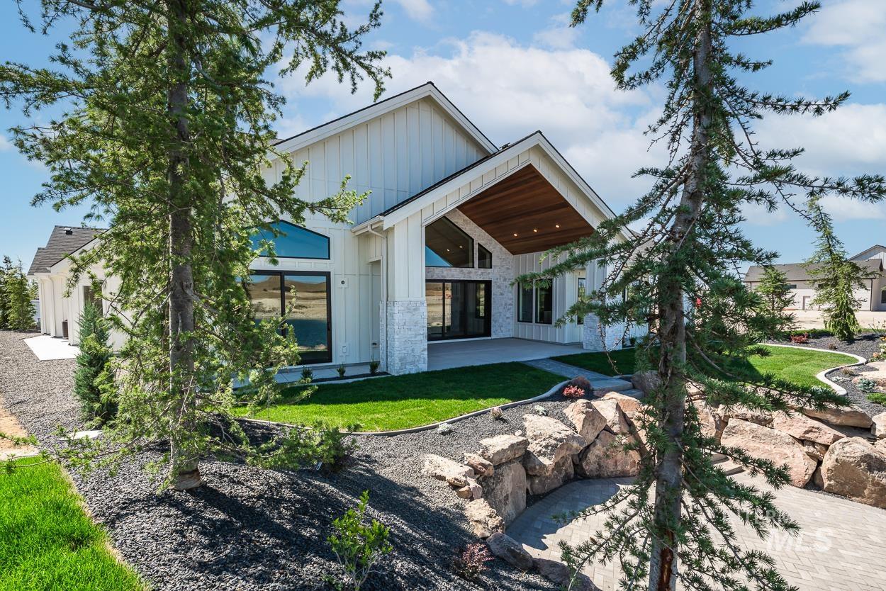Back of house featuring board and batten siding, a patio area, and a yard