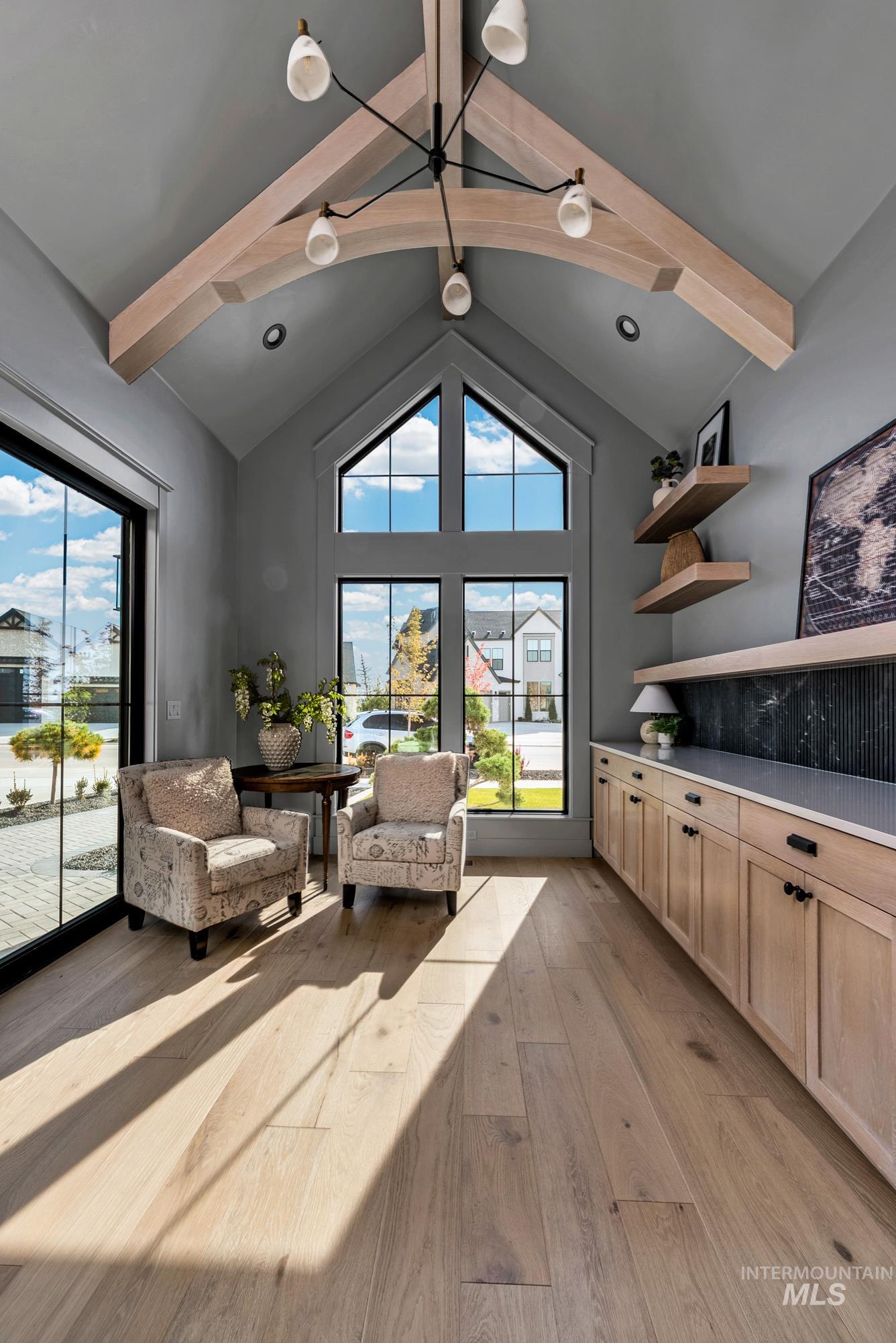 Living area with beamed ceiling, light wood finished floors, and high vaulted ceiling
