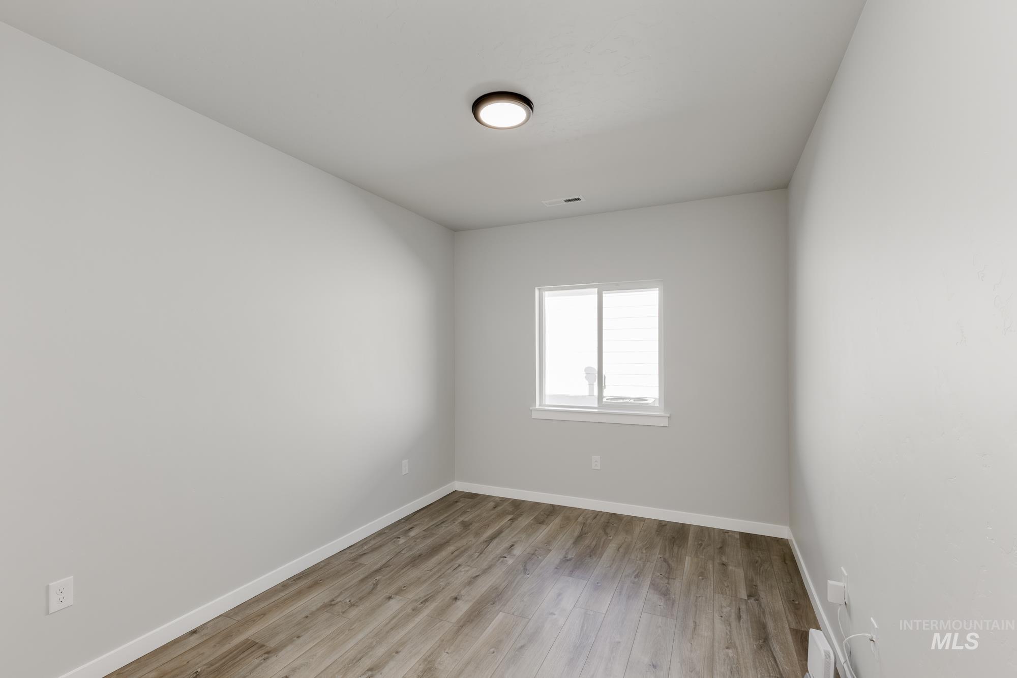 Spare room with baseboards and light wood finished floors