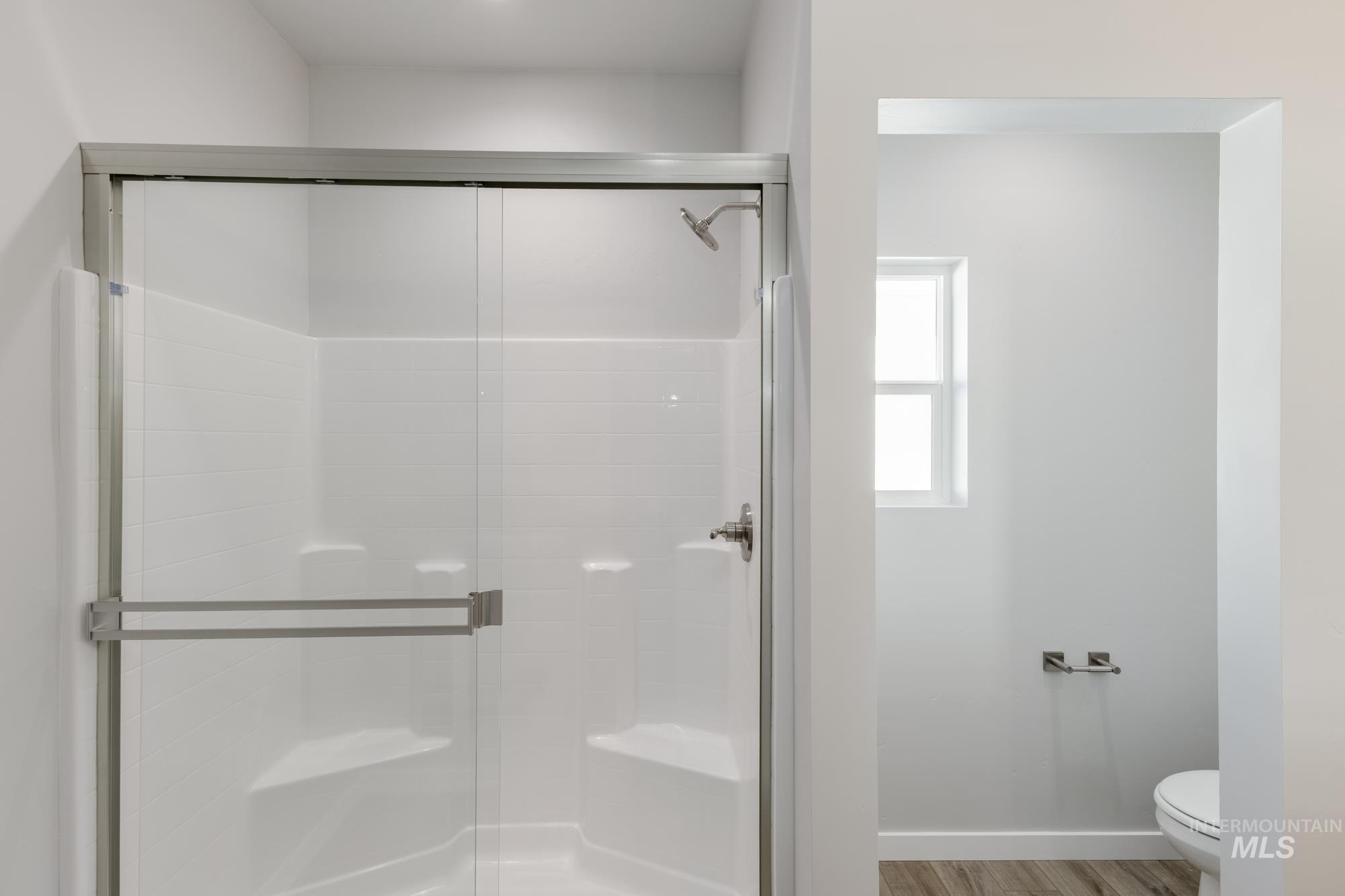 Full bathroom with a shower stall and light wood-type flooring