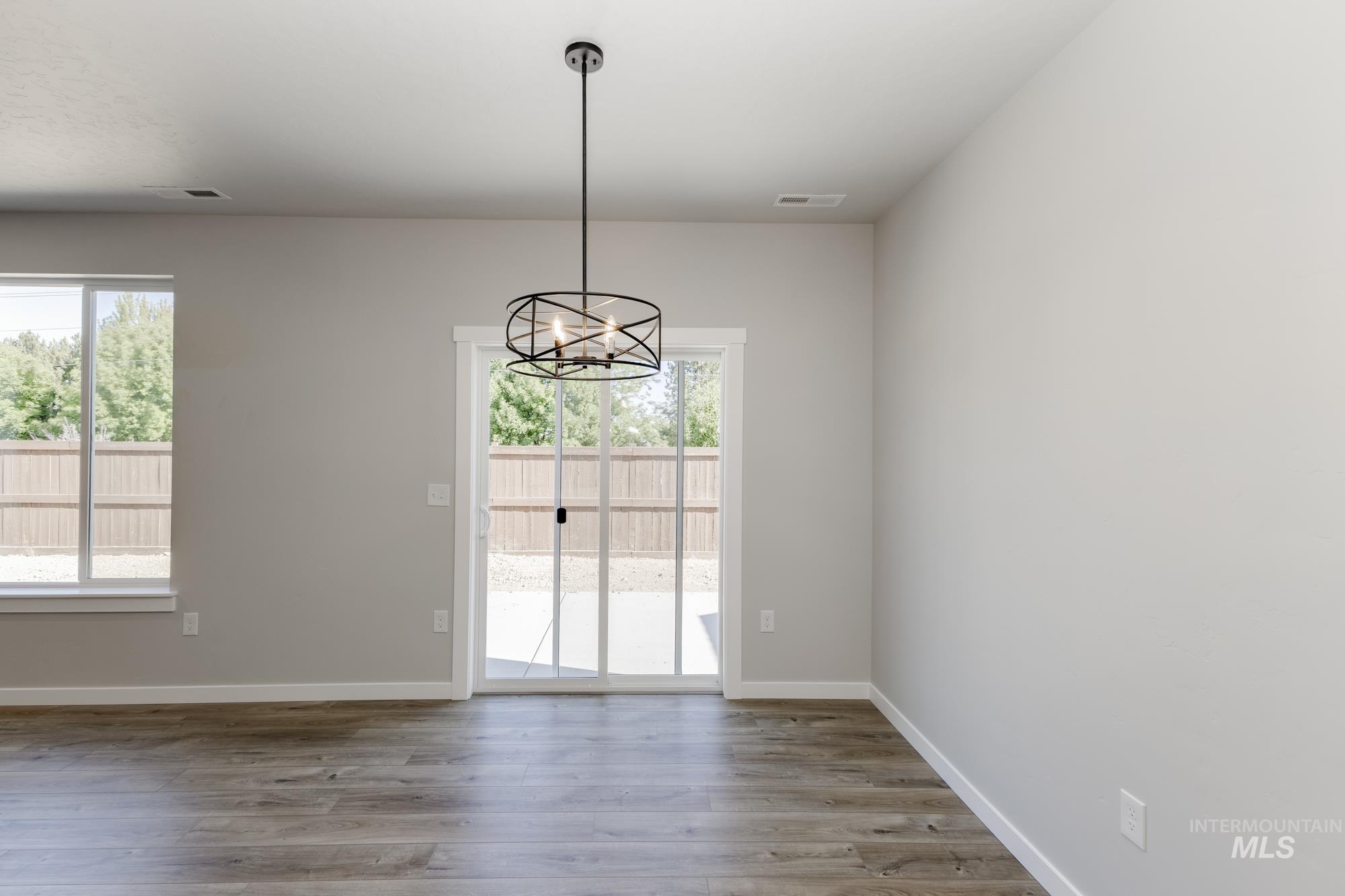 Unfurnished dining area with light wood-type flooring and a chandelier