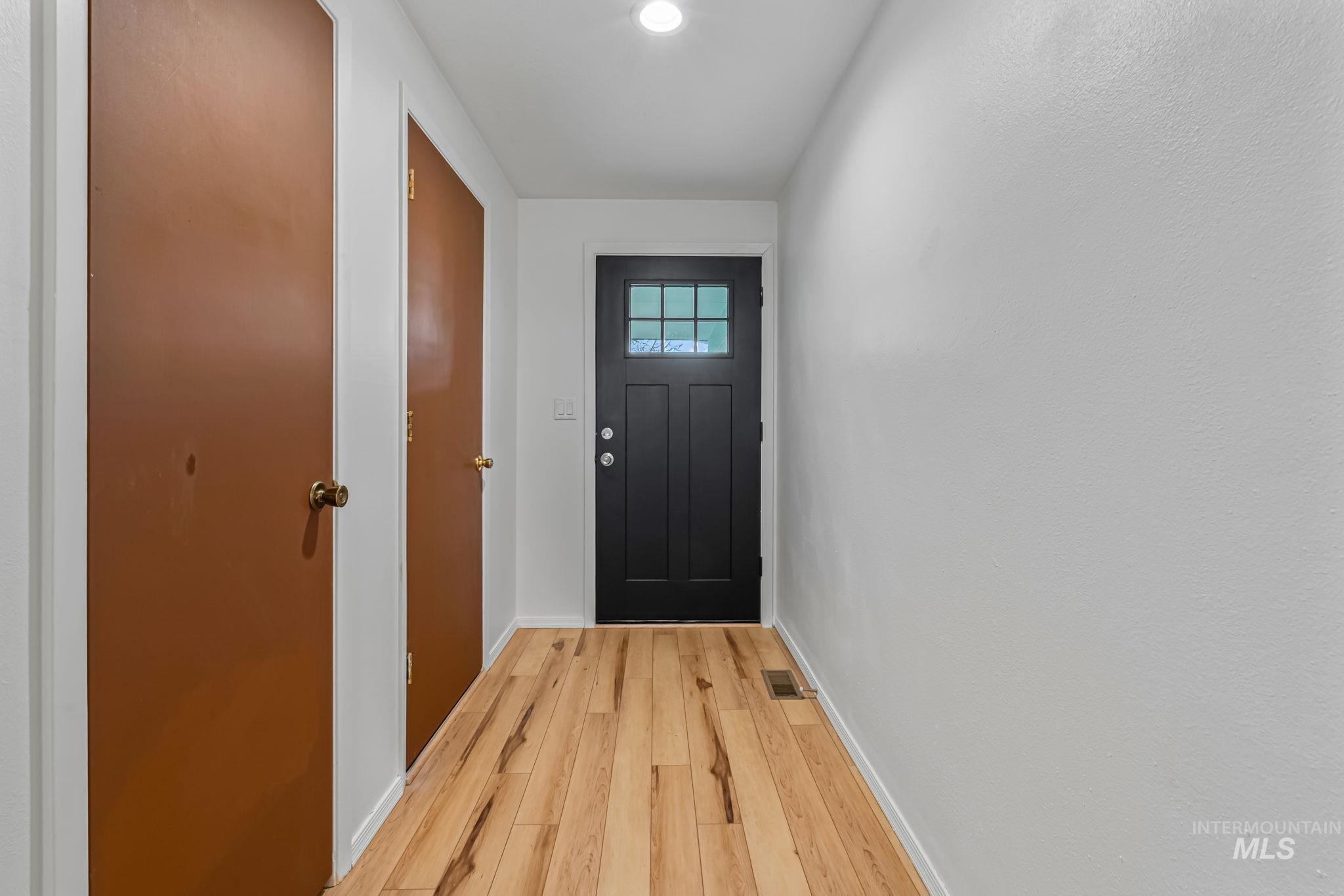 Doorway to outside with baseboards and wood finished floors