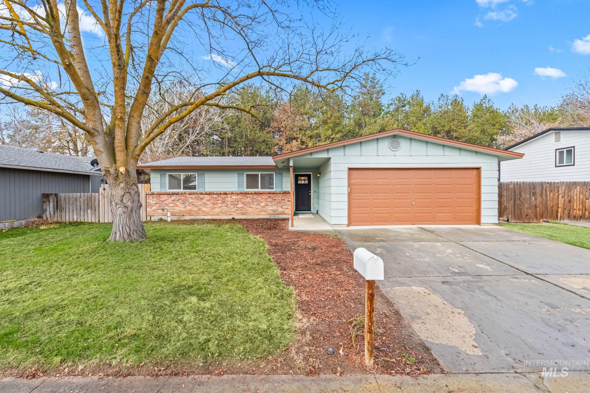 Ranch-style home featuring board and batten siding, a garage, concrete driveway, and brick siding