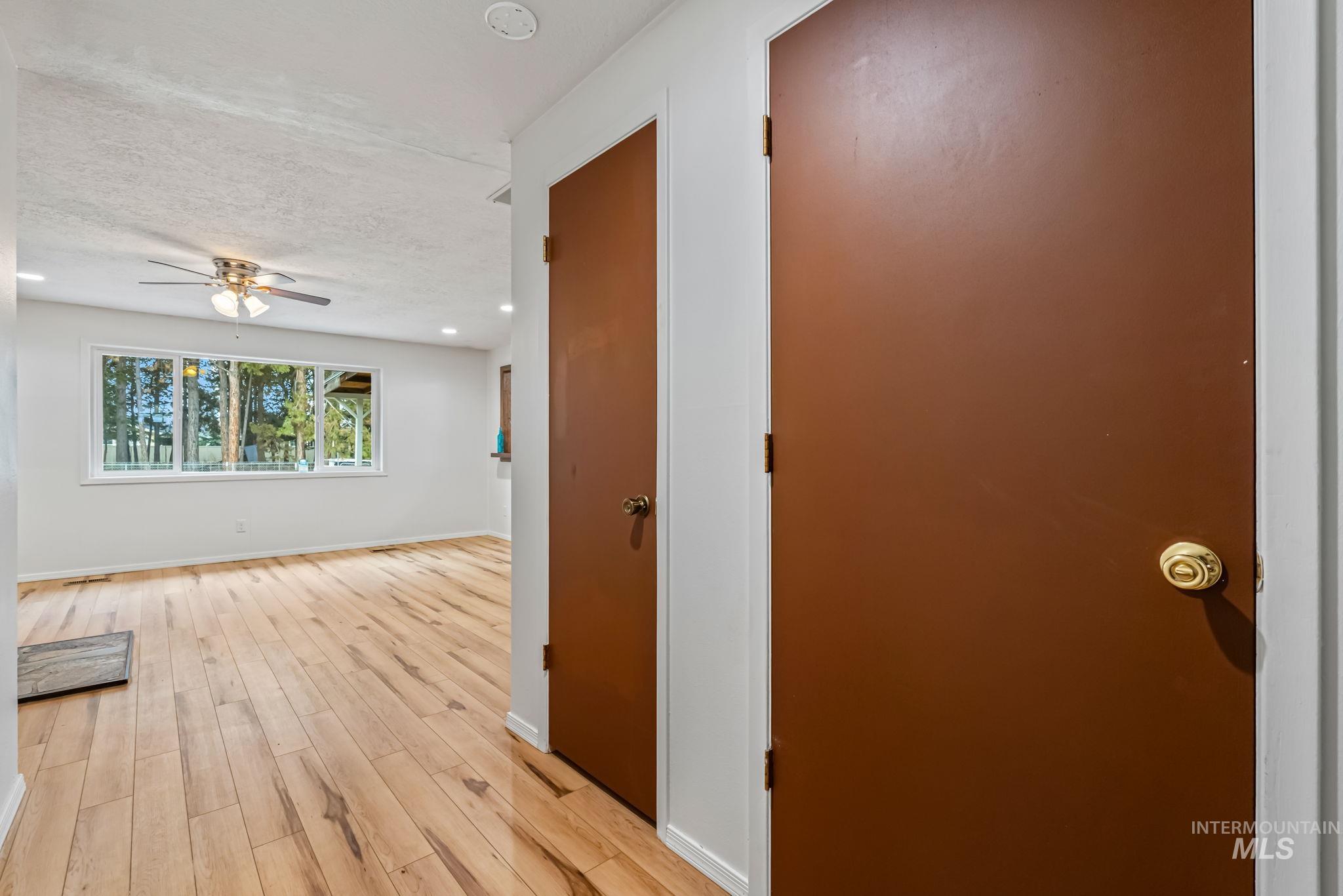 Hall featuring light wood-style floors, recessed lighting, and a textured ceiling