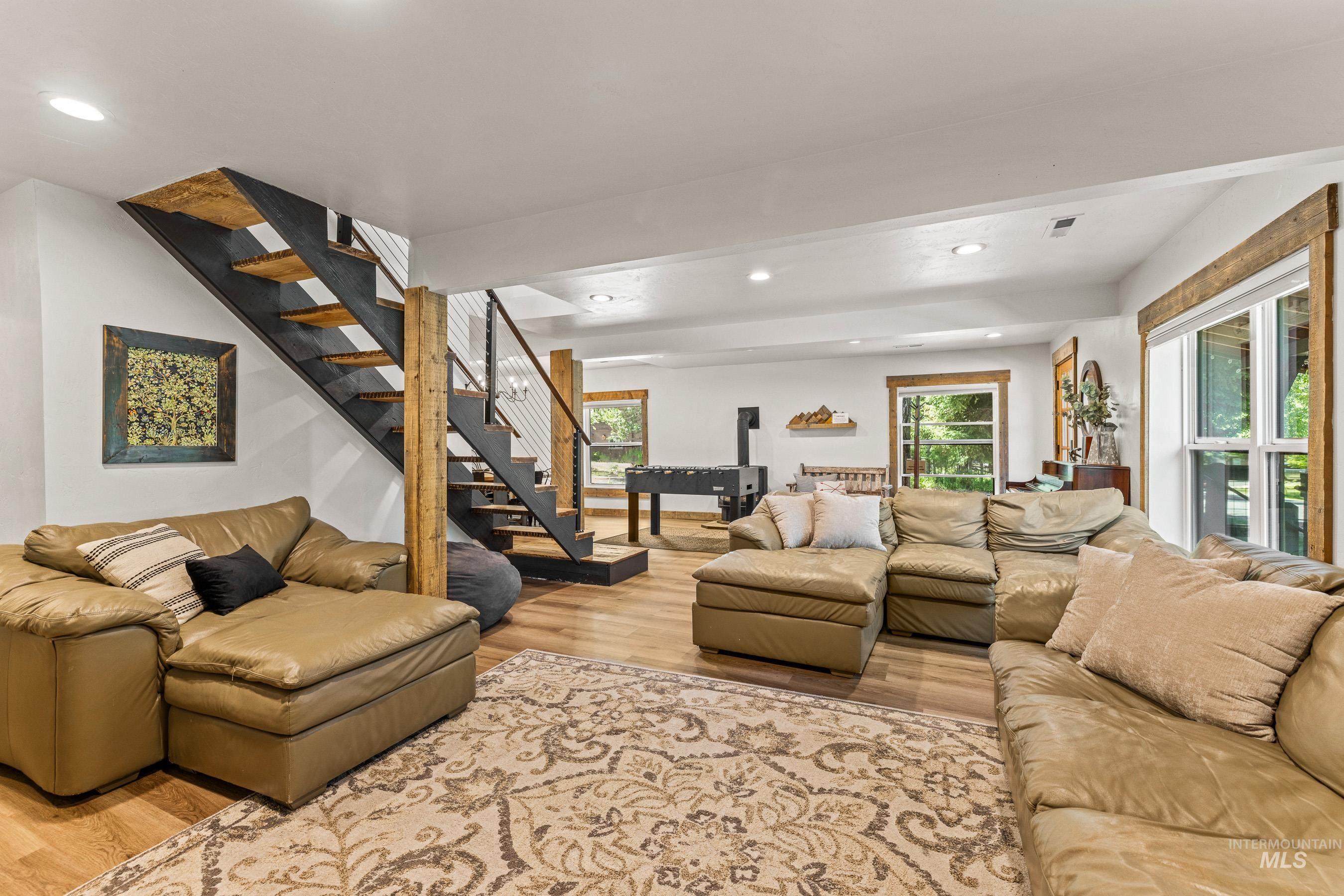 Living room featuring light wood-style flooring, stairs, healthy amount of natural light, and recessed lighting