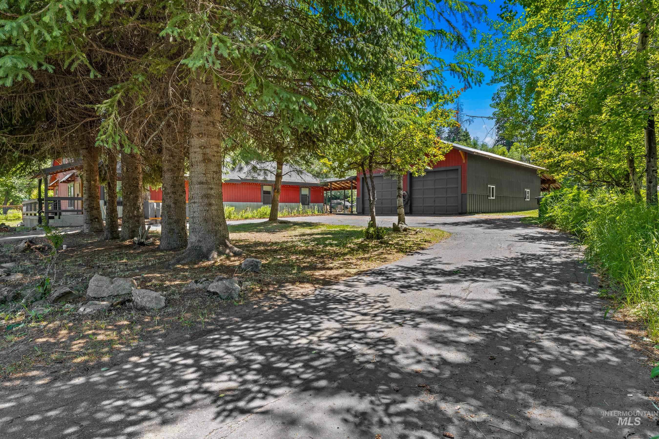 View of front of home featuring asphalt driveway and an outbuilding