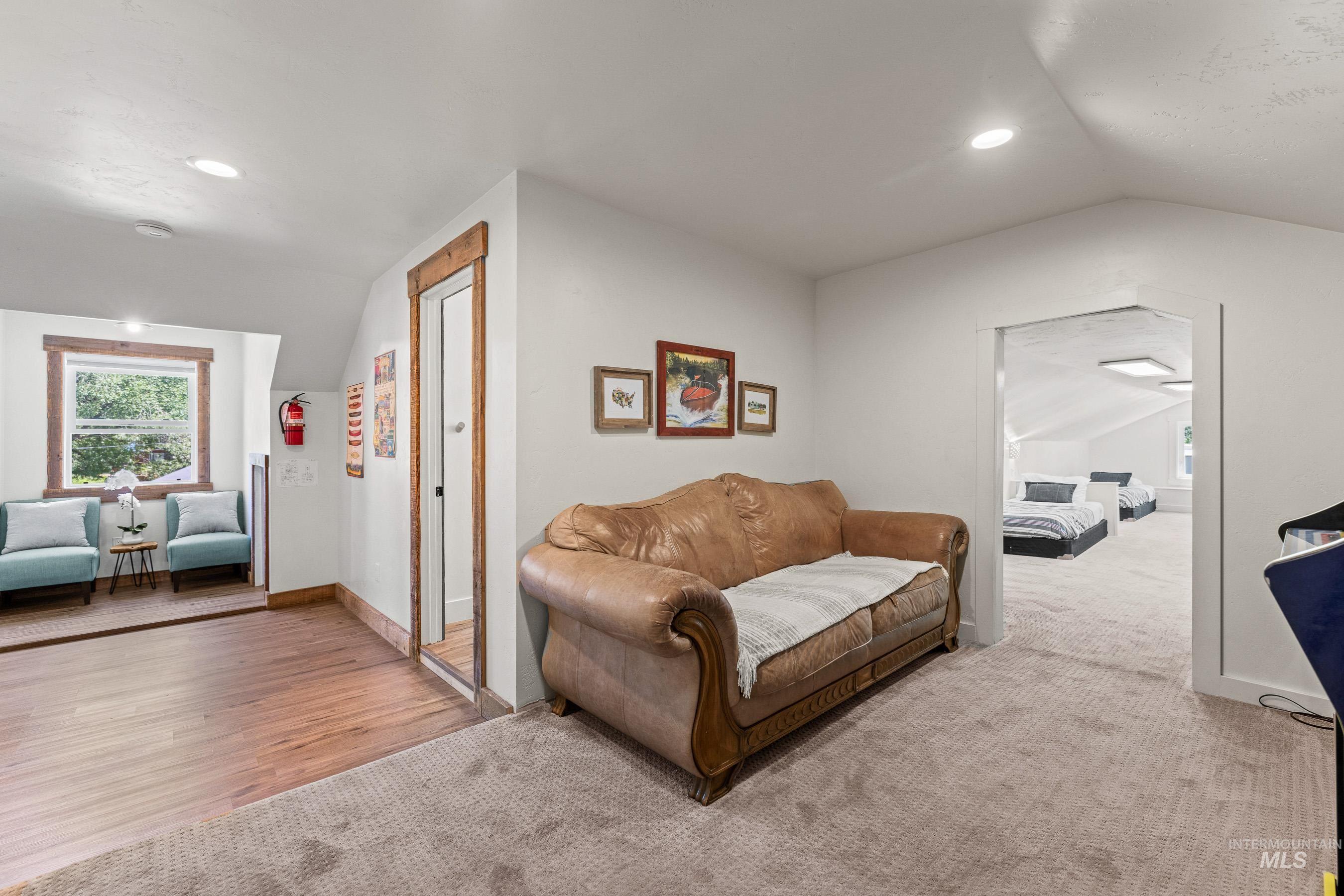 Bonus room with lofted ceiling, carpet floors, recessed lighting, and wood finished floors