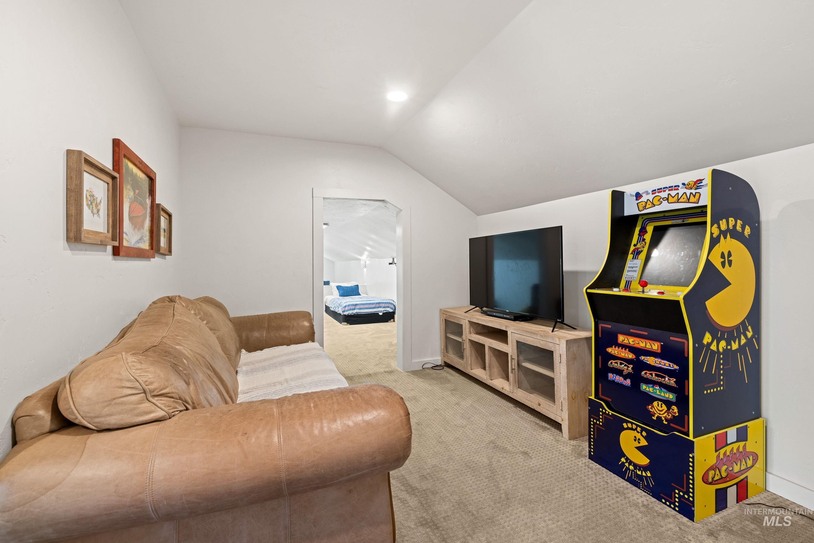 Carpeted living area with vaulted ceiling