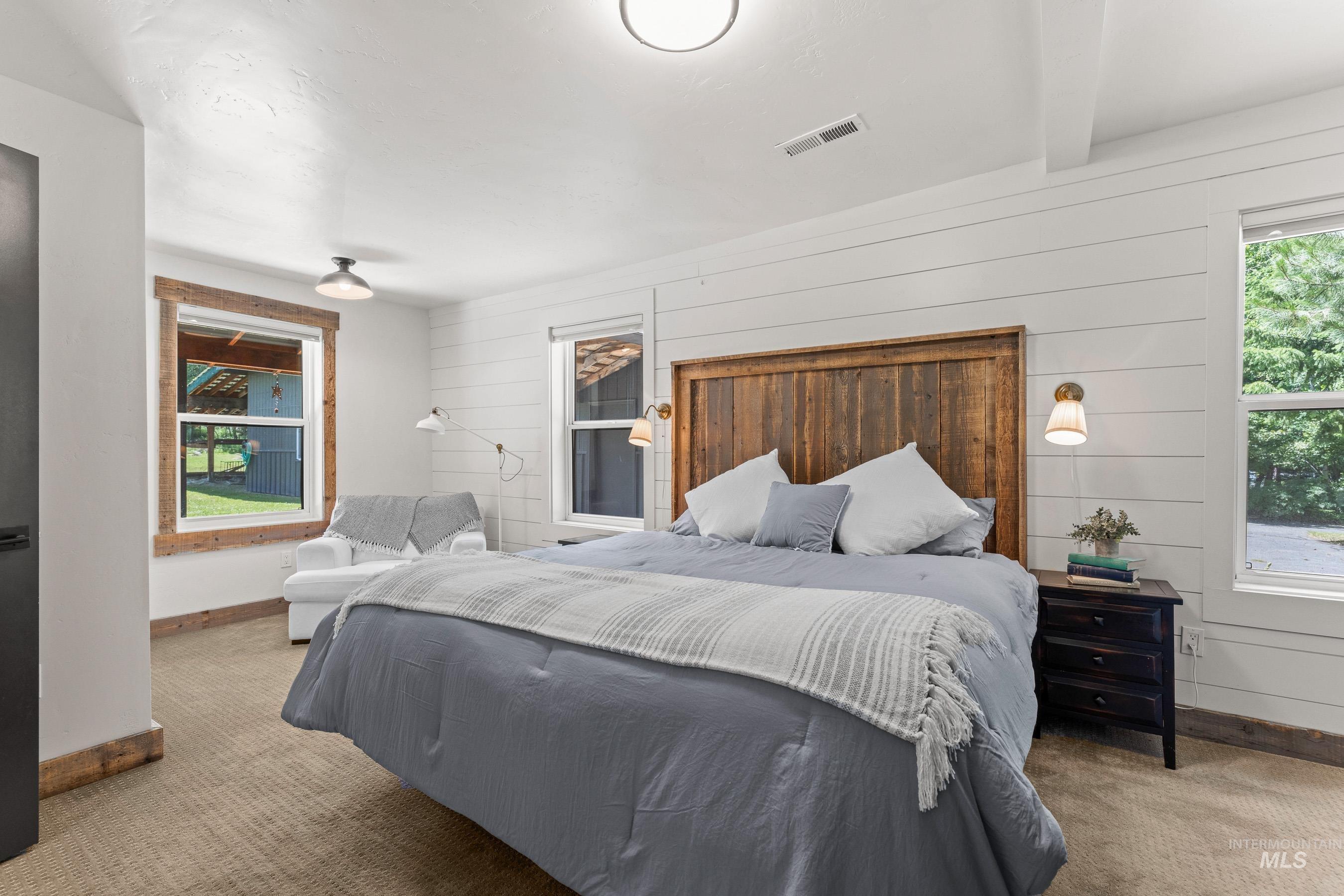 Bedroom with carpet flooring and wood walls