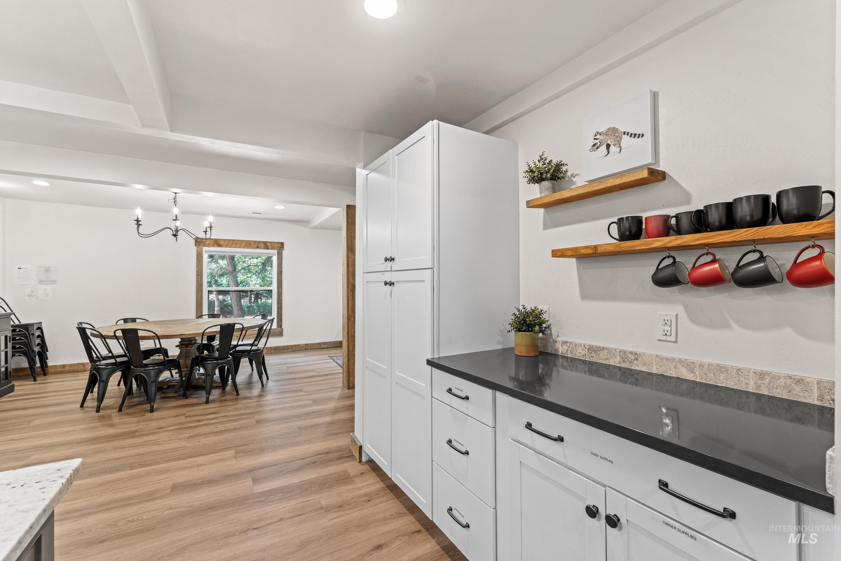 Kitchen with open shelves, white cabinets, light wood-style floors, recessed lighting, and pendant lighting