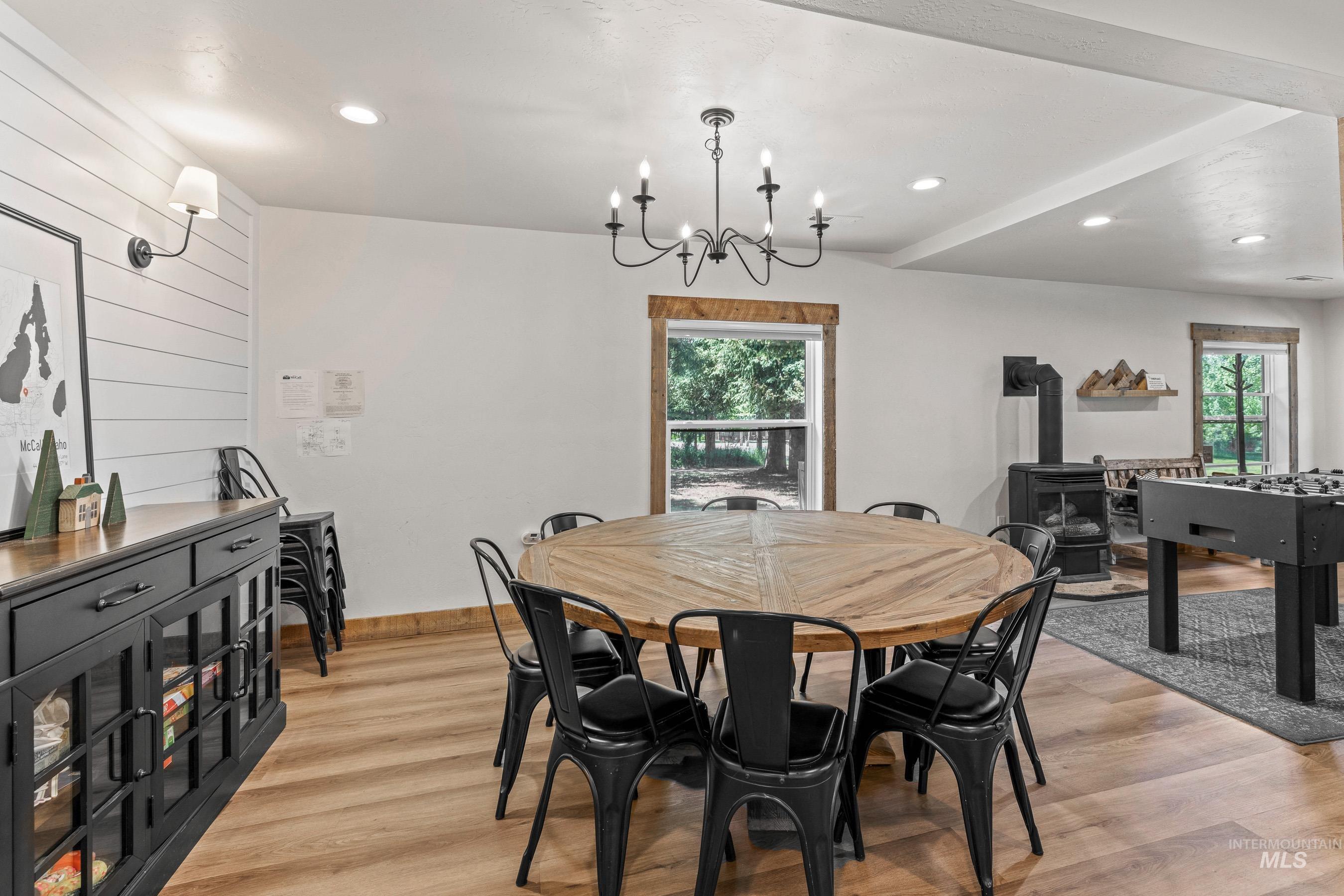 Dining space with a wood stove, light wood-style flooring, a chandelier, and recessed lighting