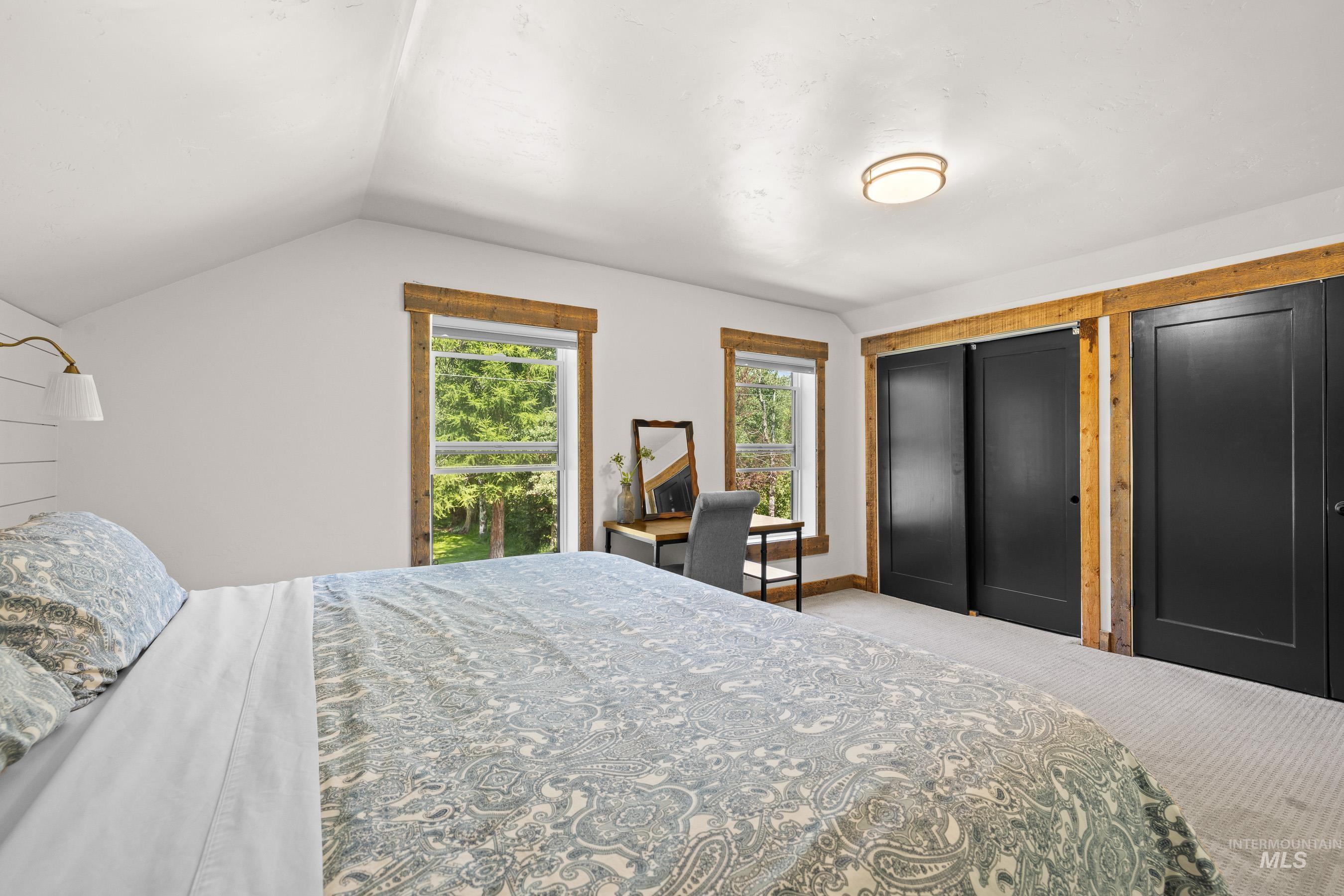 Bedroom with vaulted ceiling, carpet, and a closet