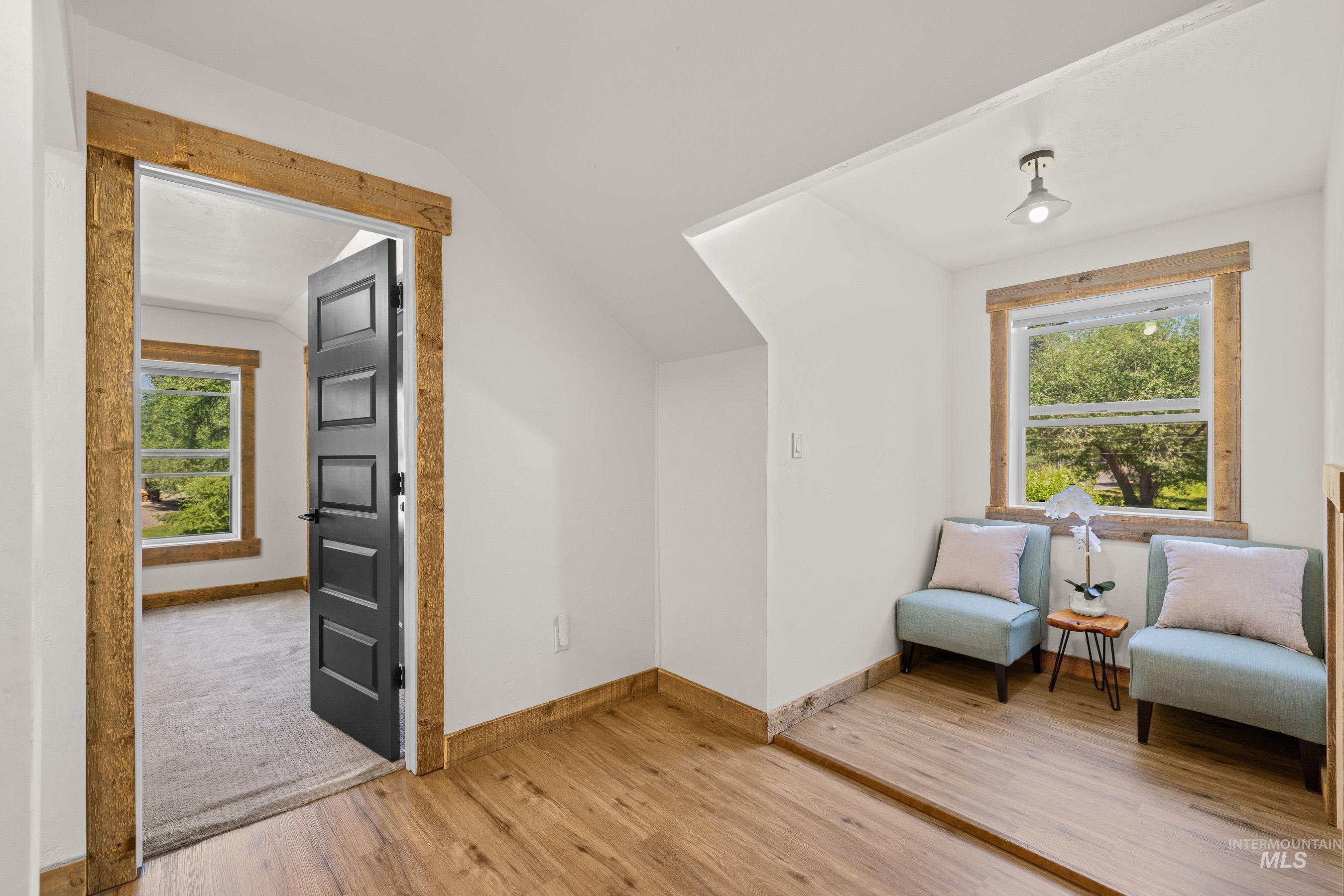 Sitting room with vaulted ceiling and light wood-type flooring