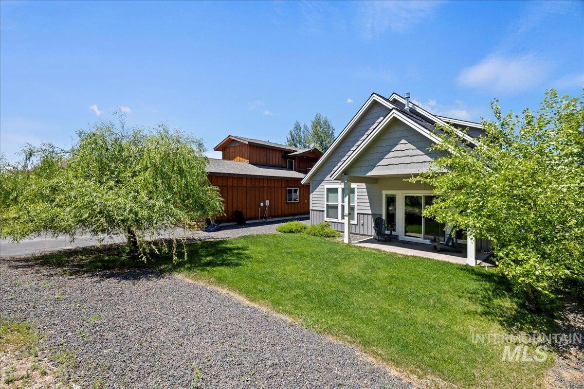 Back of house featuring a lawn and a patio