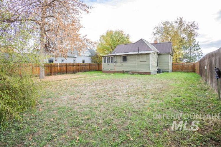 Rear view of house with a metal roof and a fenced backyard