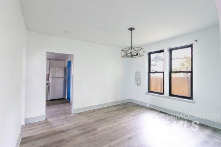Spare room with light wood finished floors and a chandelier