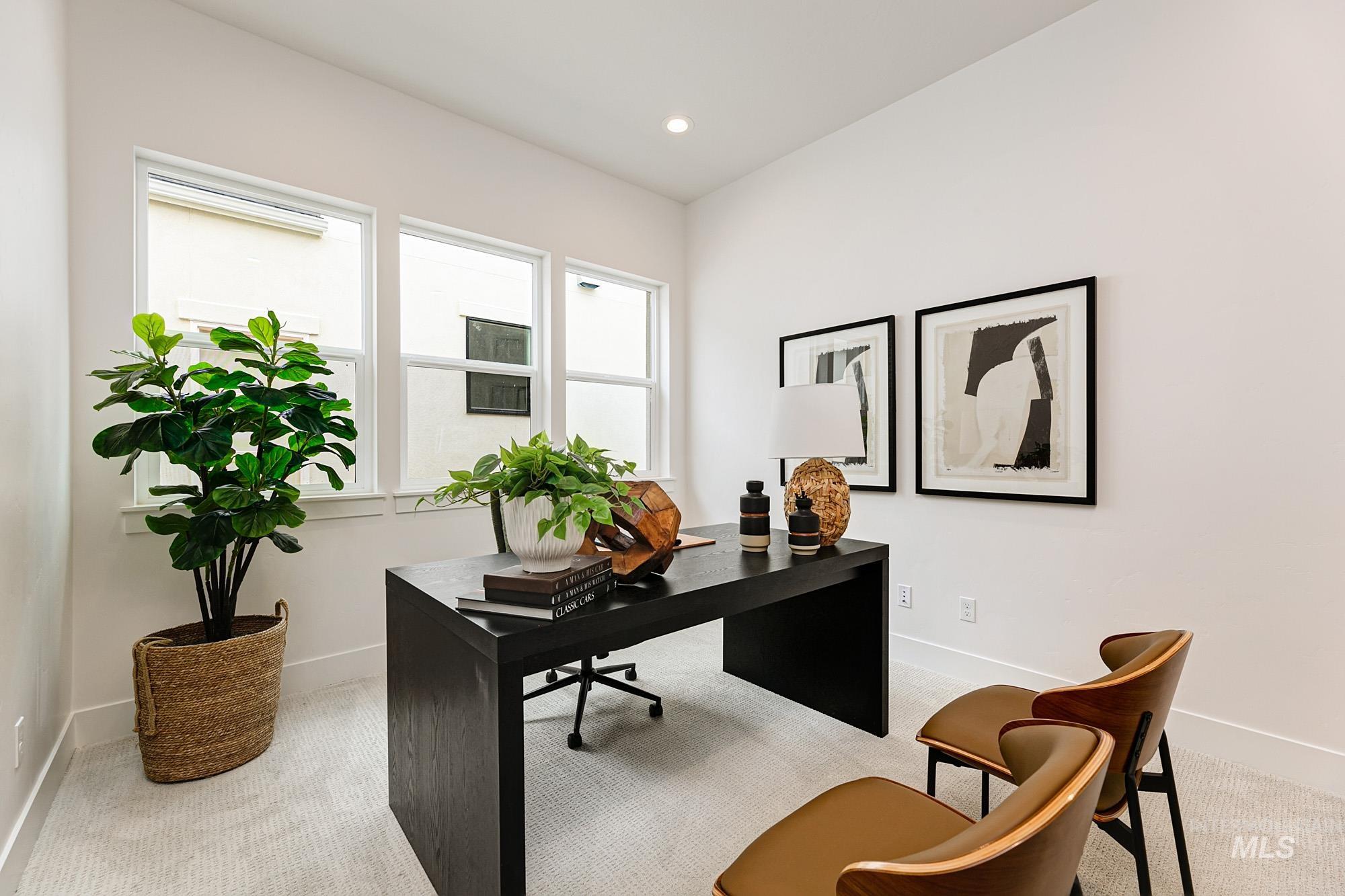 Office space with light colored carpet and recessed lighting