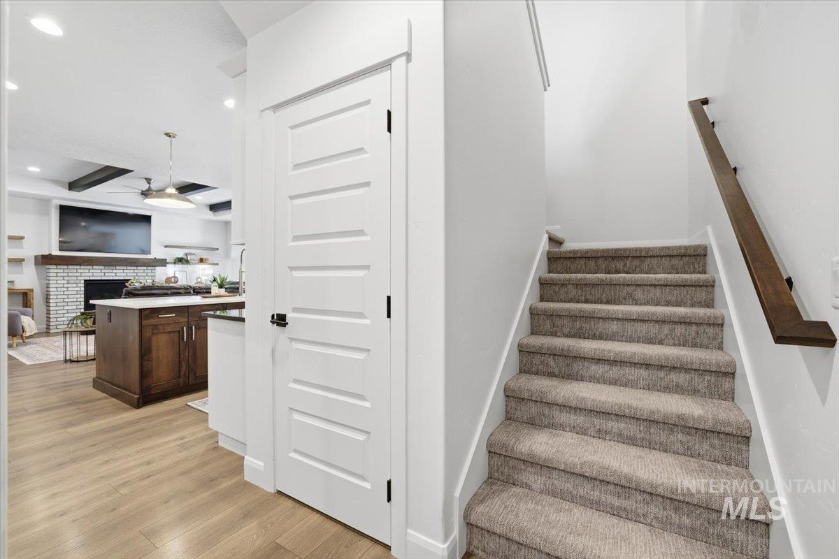 Stairway with a fireplace, wood finished floors, a ceiling fan, and recessed lighting