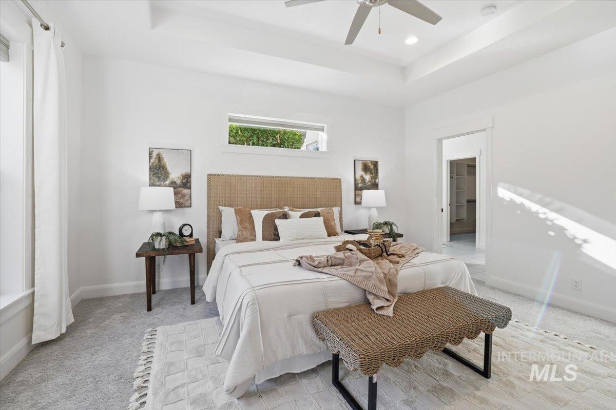 Bedroom featuring a raised ceiling, light colored carpet, ceiling fan, and recessed lighting