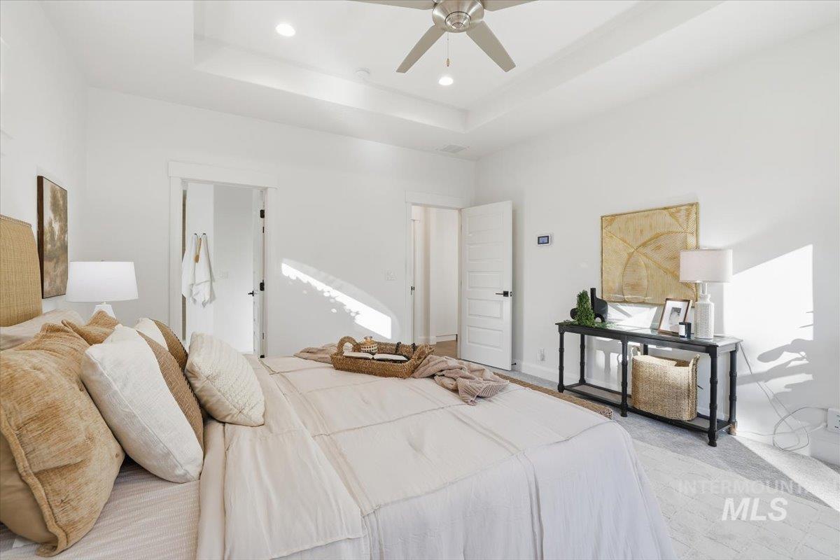 Bedroom featuring a tray ceiling, carpet floors, a ceiling fan, and recessed lighting