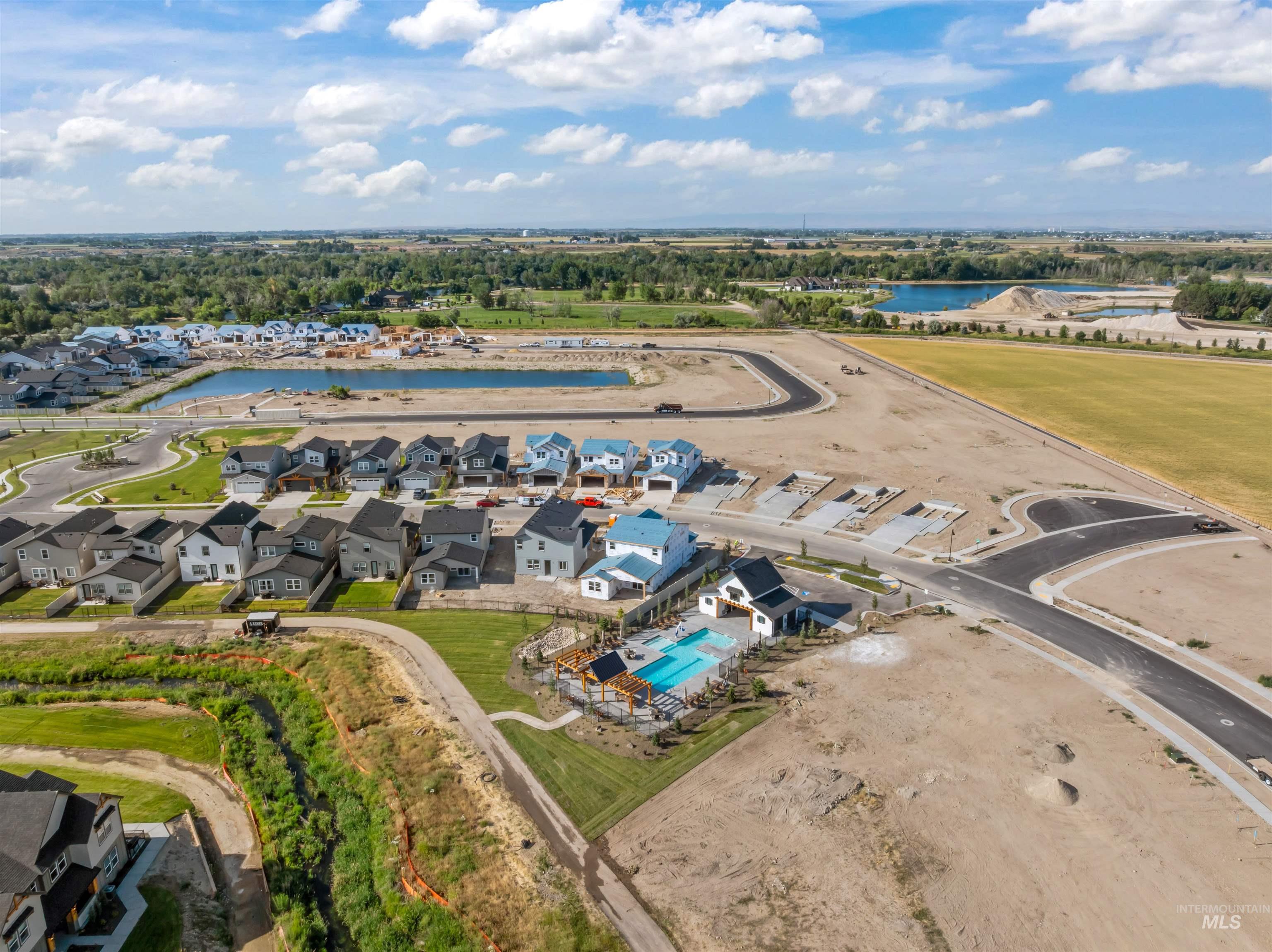 Aerial view of residential area featuring a pool and a large body of water
