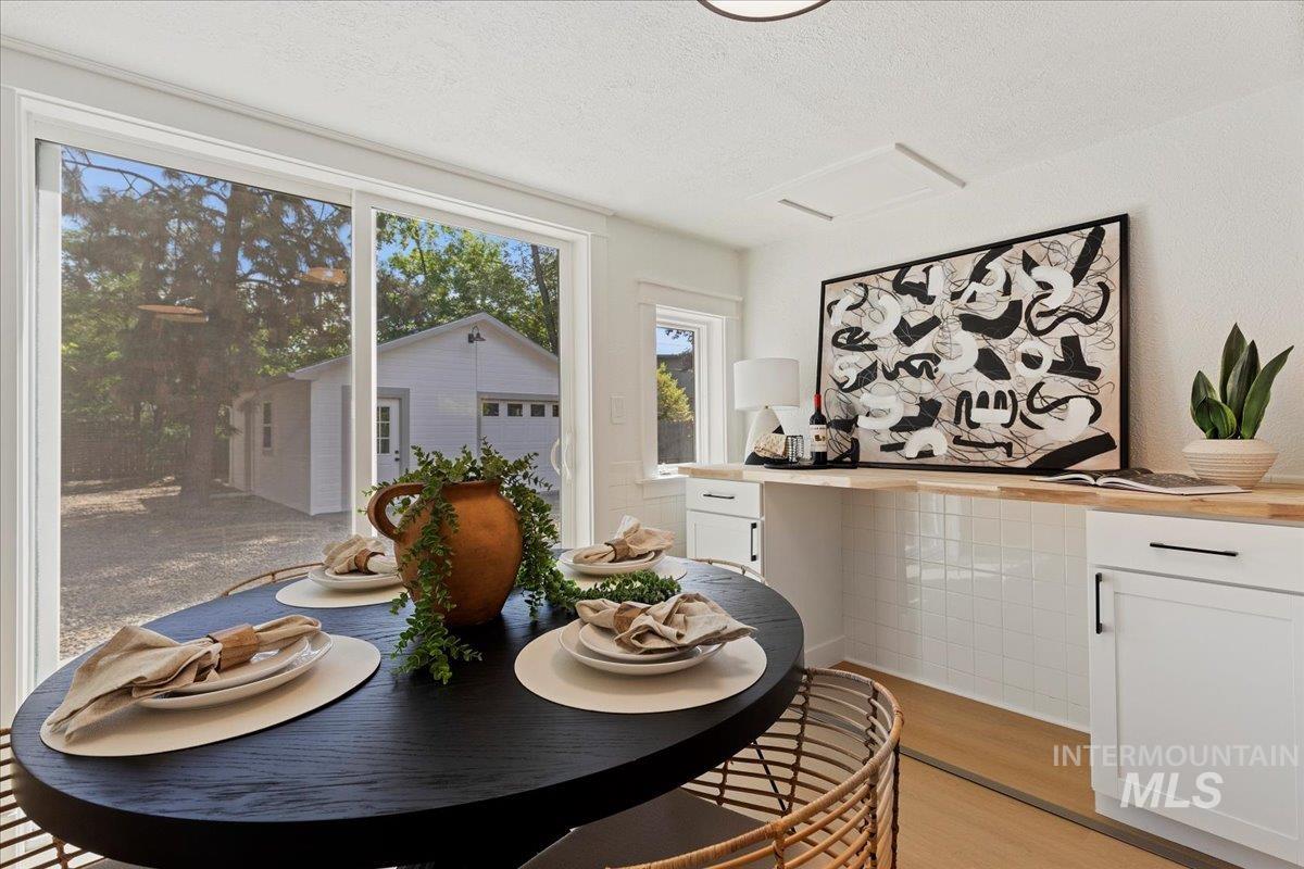 Dining space with light wood-style floors and a textured ceiling