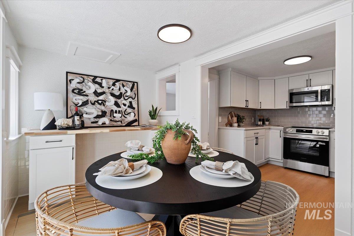 Dining space with a textured ceiling and light wood-style floors