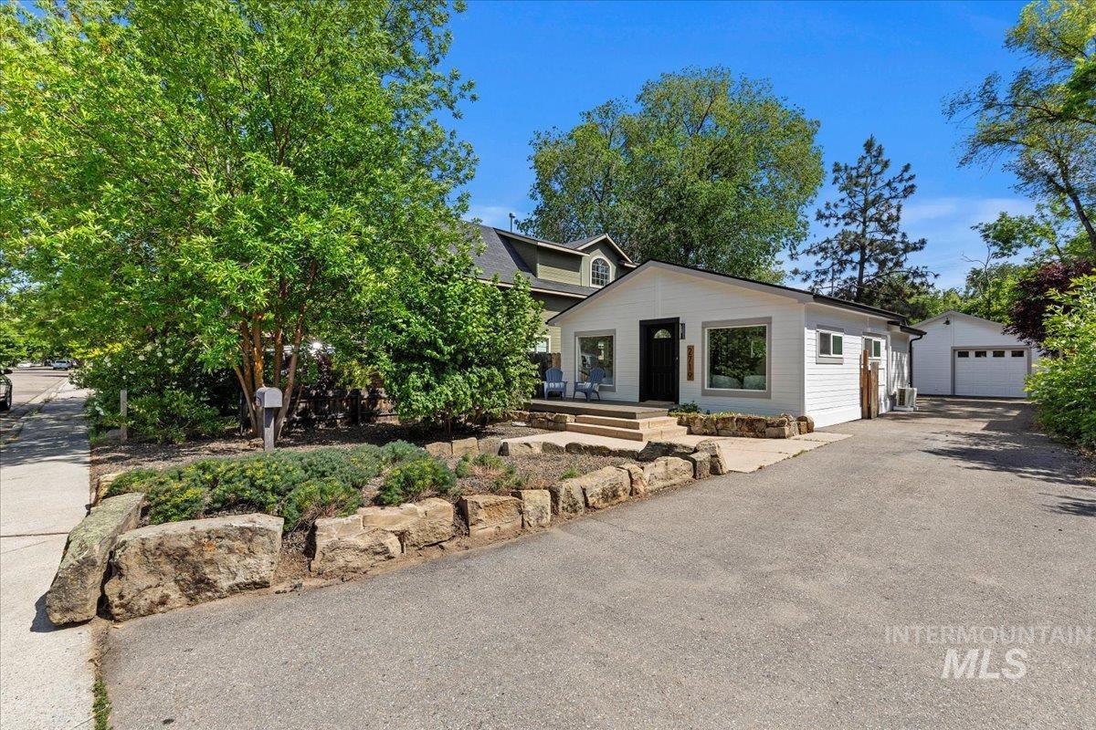 View of front facade featuring a detached garage, driveway, and an outdoor structure