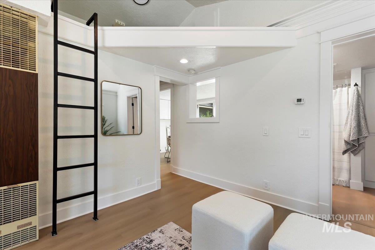 Sitting room featuring a heating unit, wood finished floors, and recessed lighting