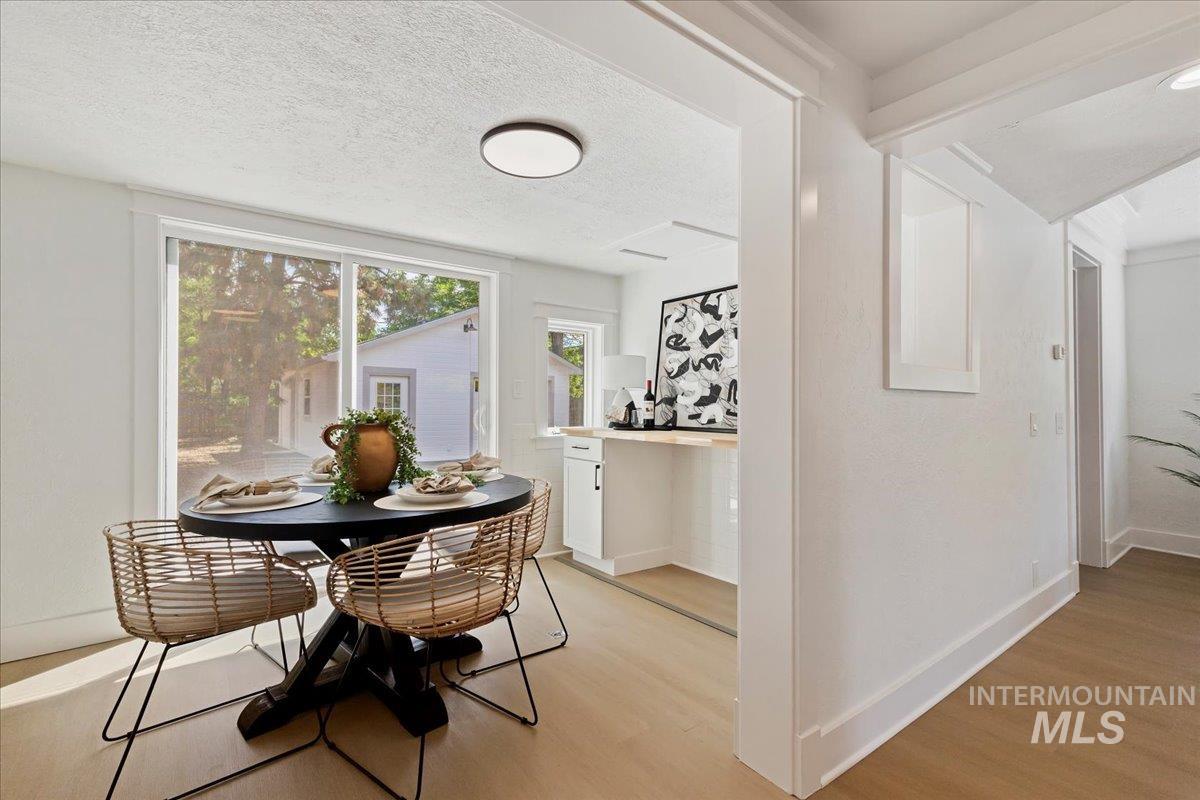 Dining room featuring light wood-style flooring and a textured ceiling