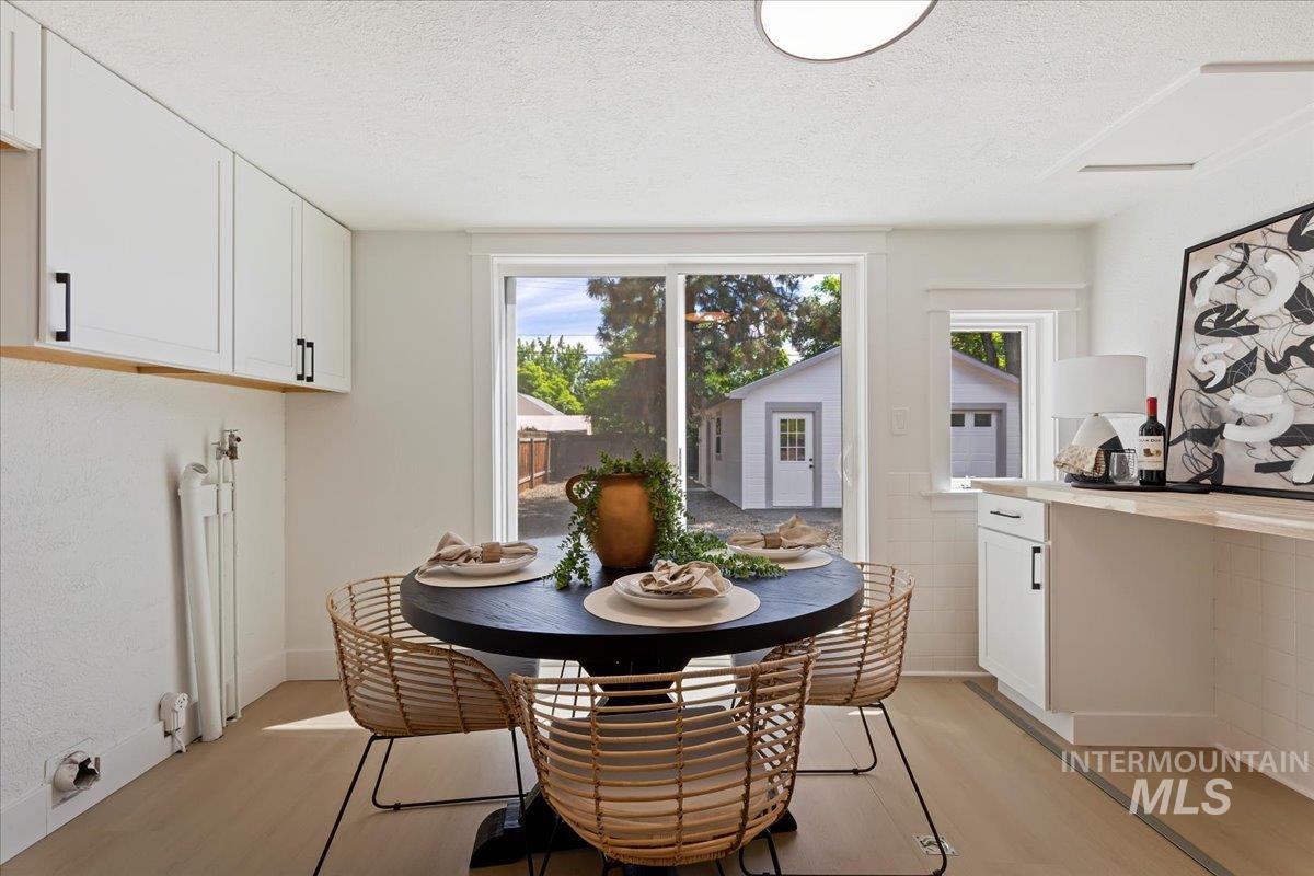 Dining area featuring a textured ceiling and light wood finished floors