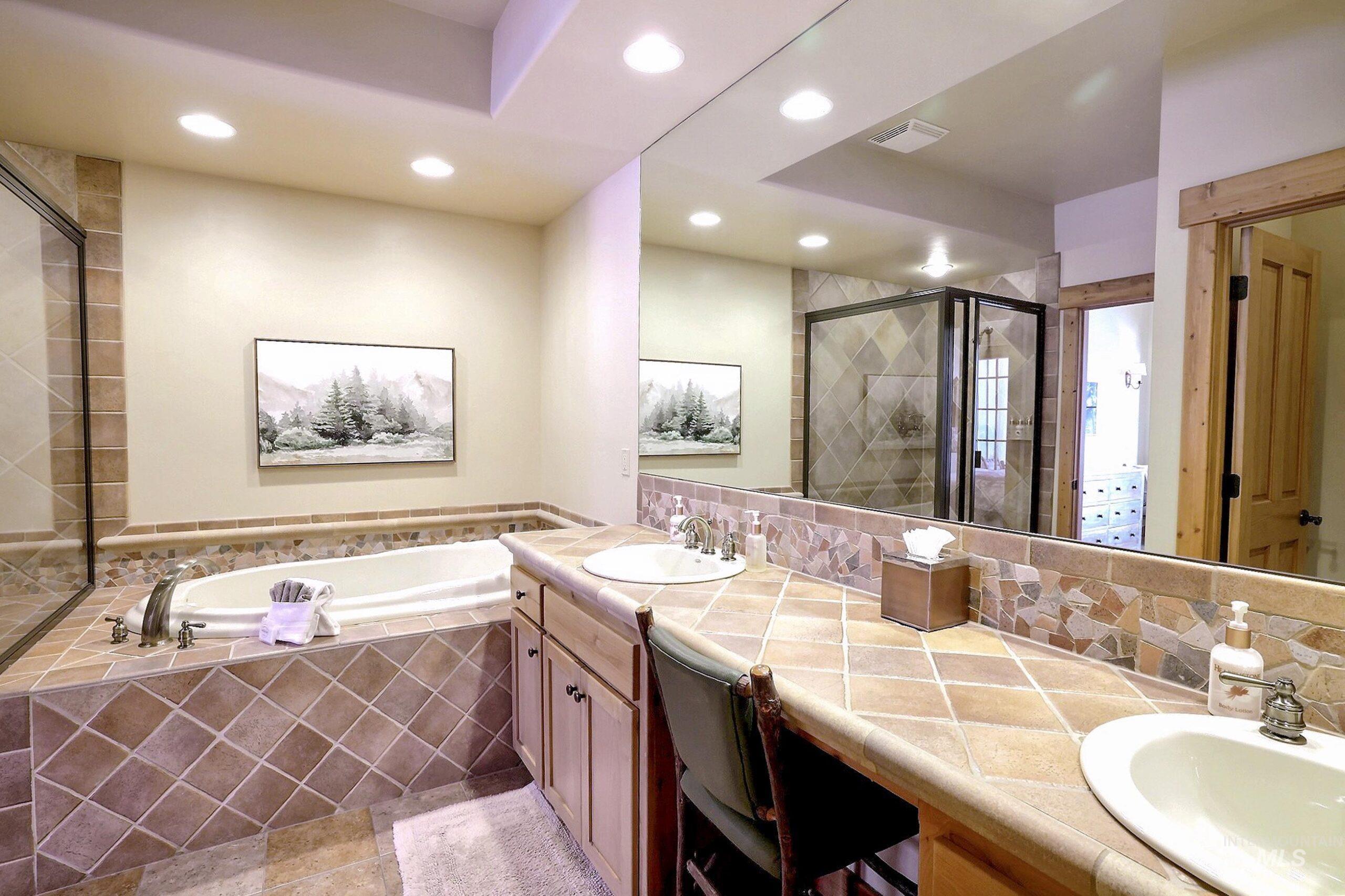 Bathroom with a bath, double vanity, recessed lighting, and a shower stall