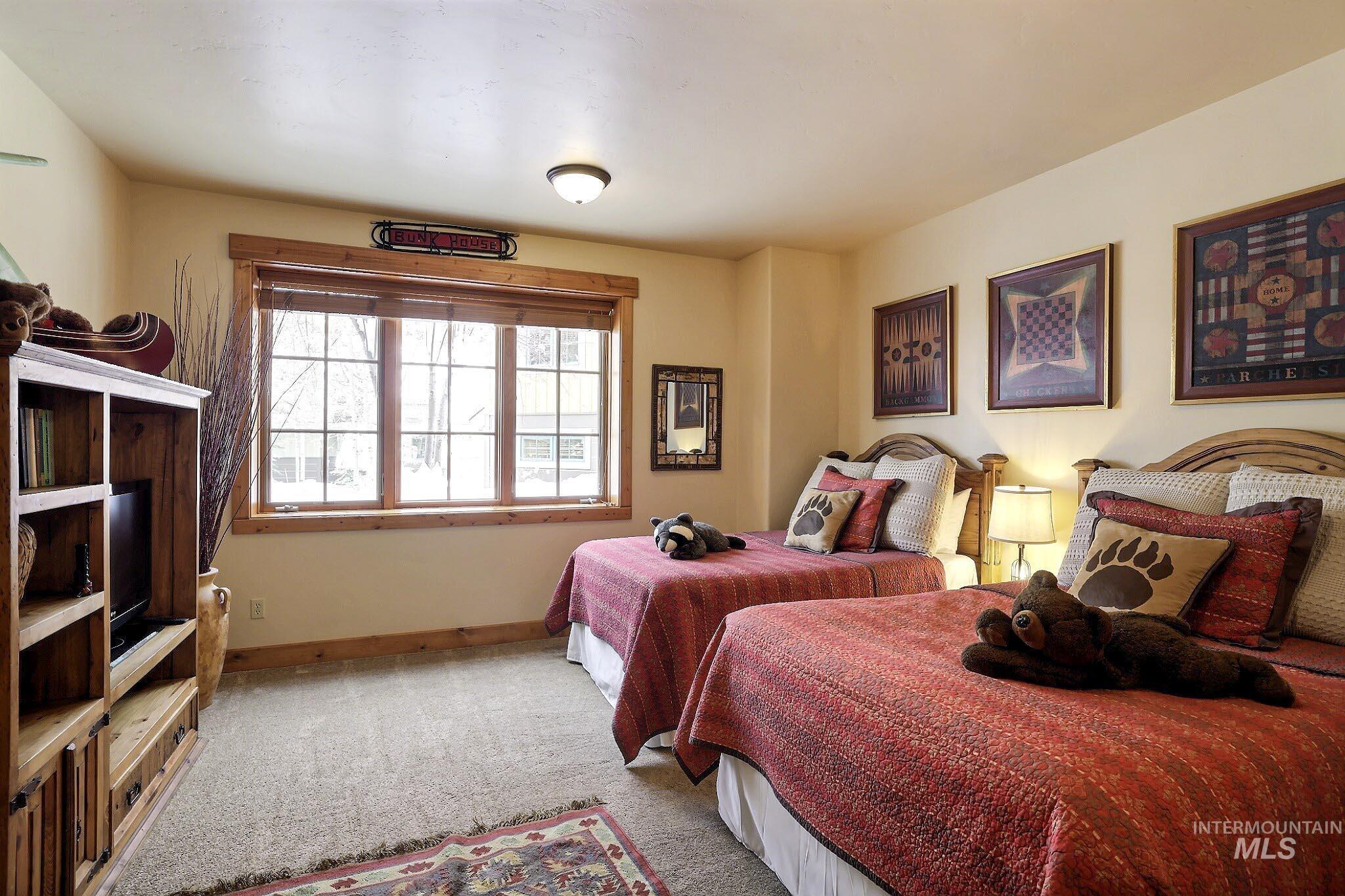 Bedroom with baseboards and light colored carpet