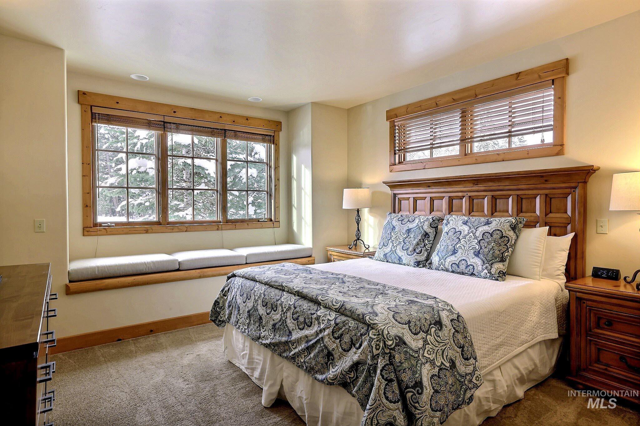 Carpeted bedroom with multiple windows