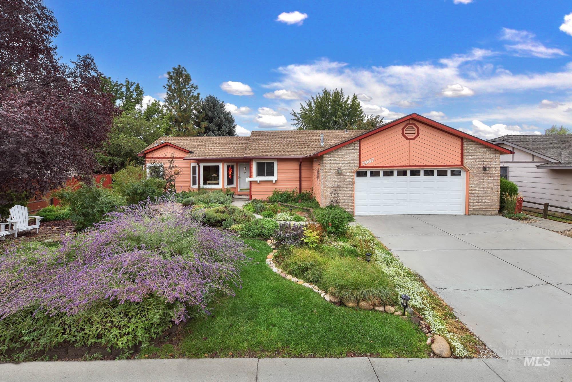 Ranch-style house featuring concrete driveway, an attached garage, and brick siding