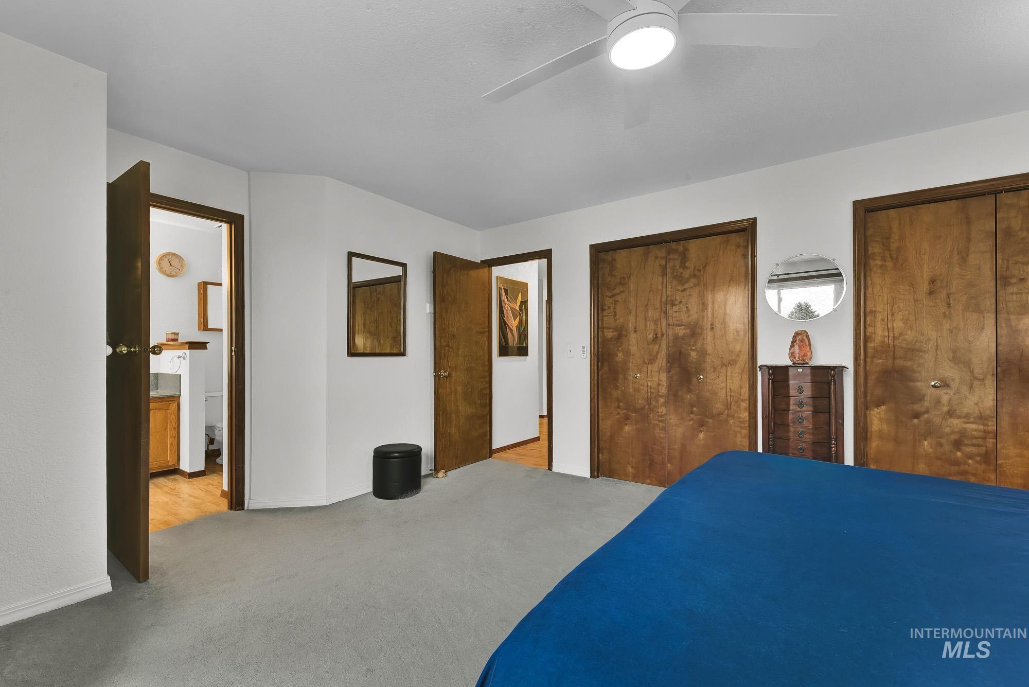 Bedroom featuring two closets, ceiling fan, and carpet floors