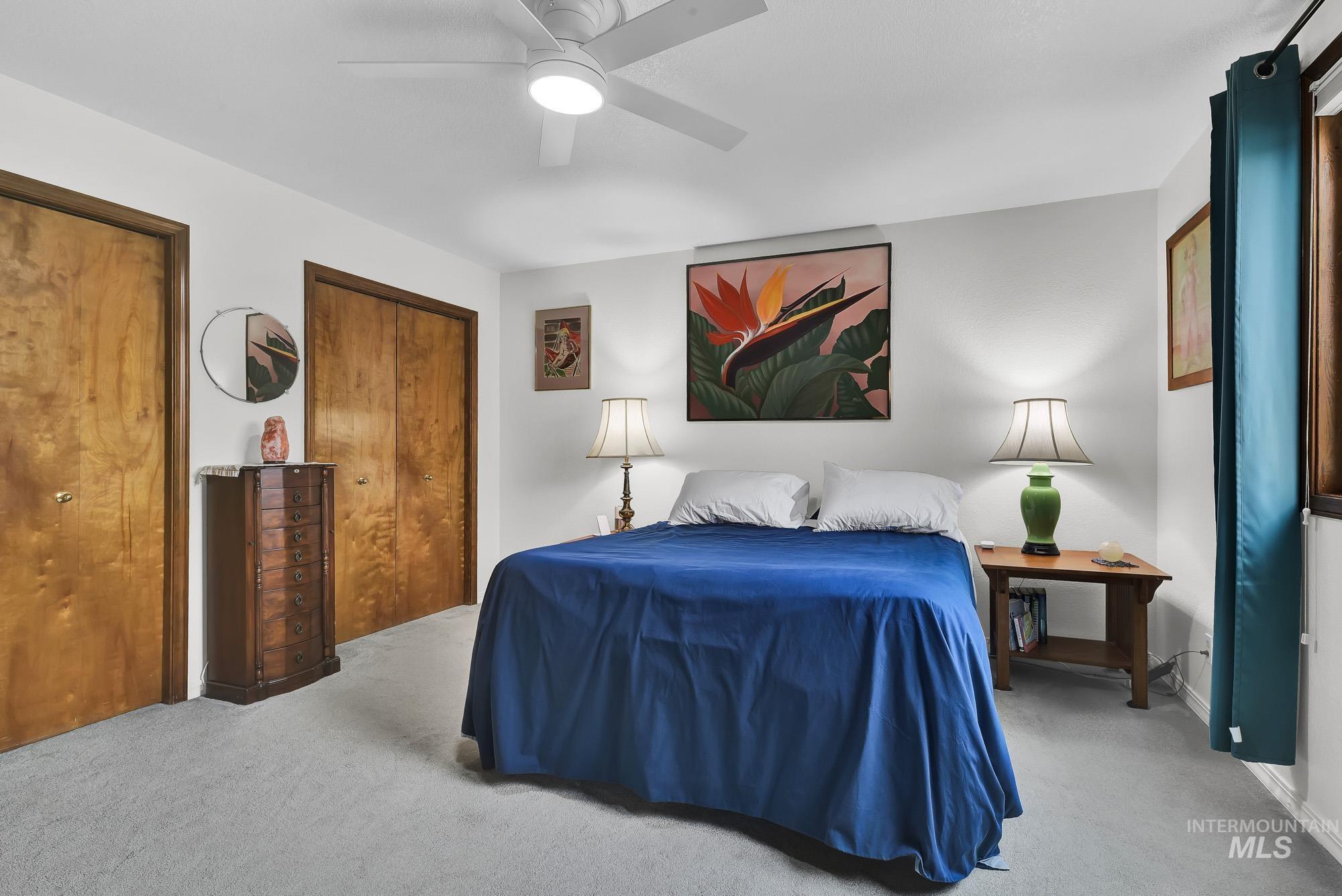 Bedroom featuring carpet floors, two closets, and a ceiling fan