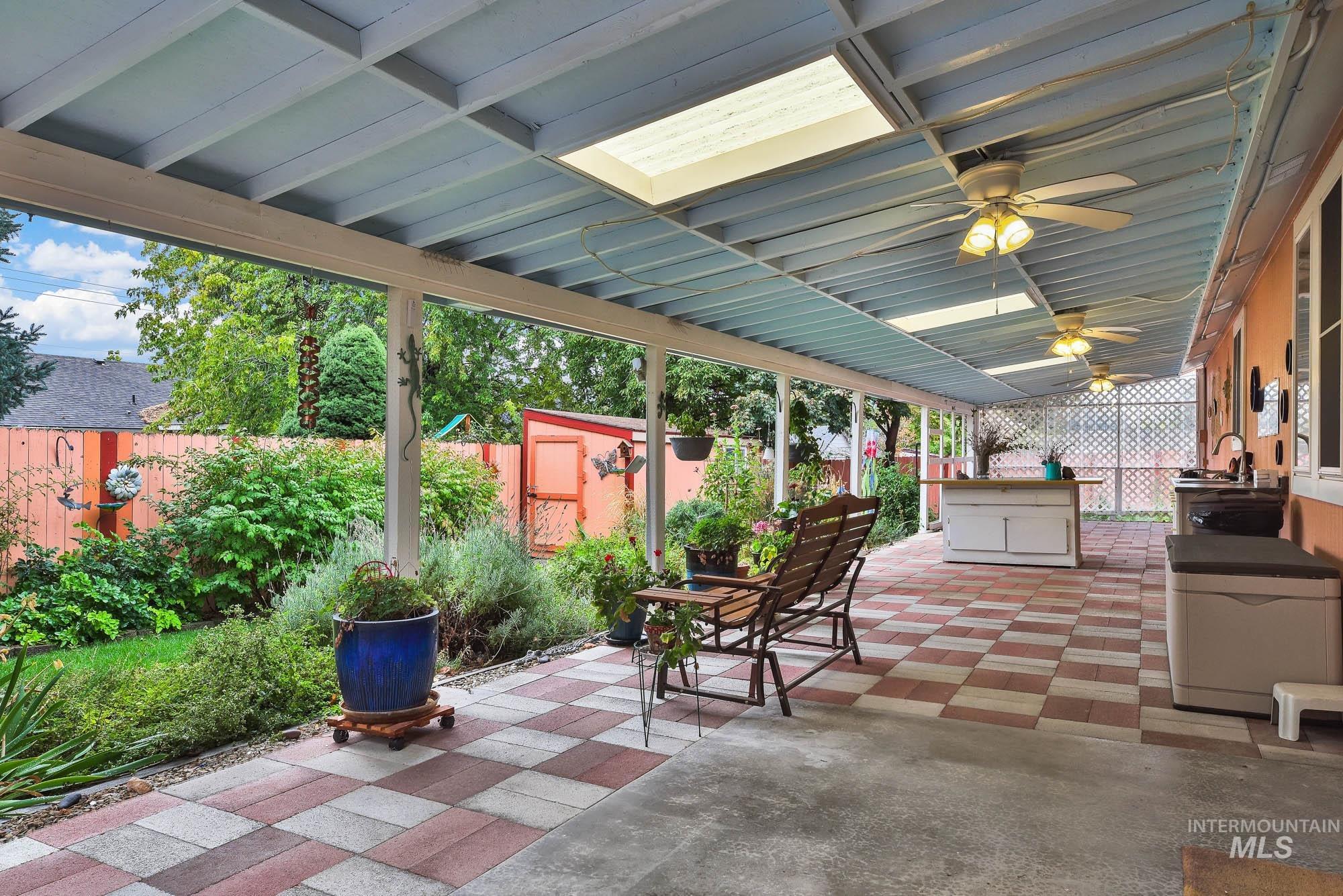Fenced backyard with a patio and ceiling fan