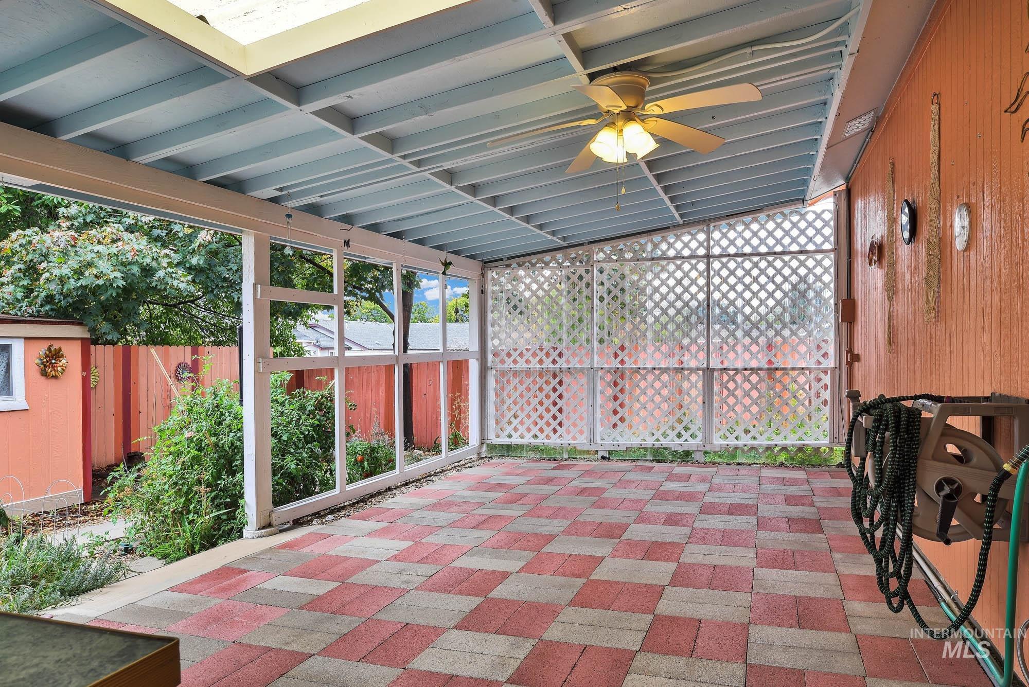 Fenced backyard with a patio and a ceiling fan
