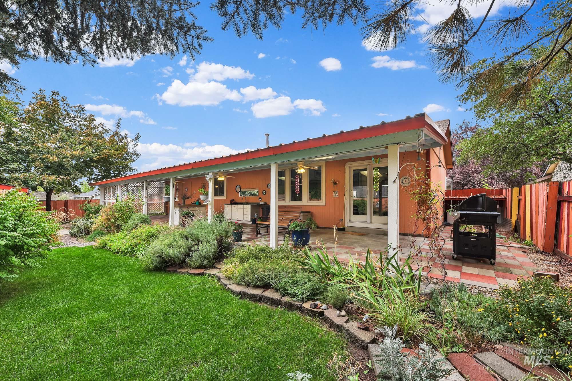 Back of house with a fenced backyard, a patio area, a ceiling fan, and a metal roof