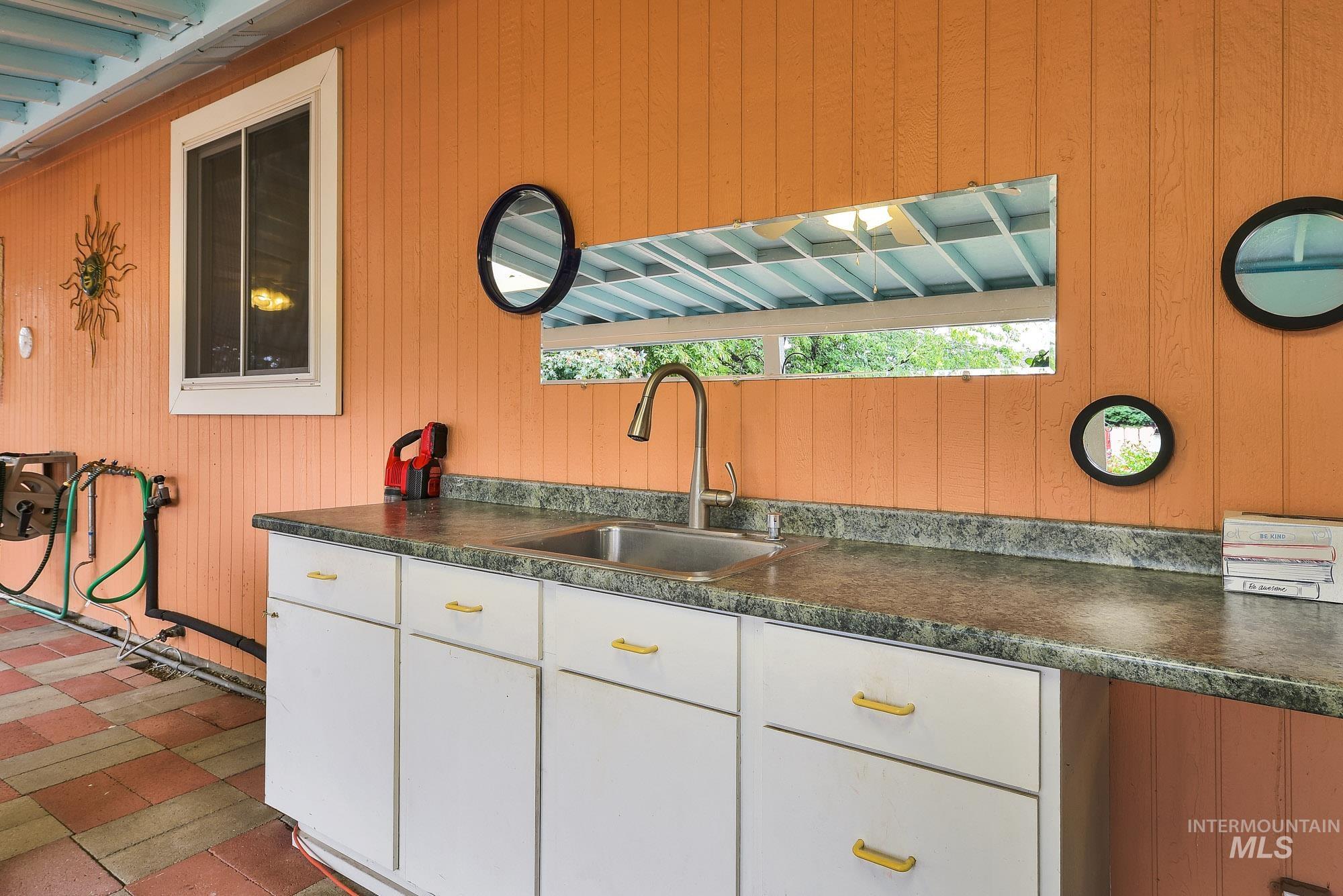 Kitchen featuring dark countertops, white cabinets, and wood walls