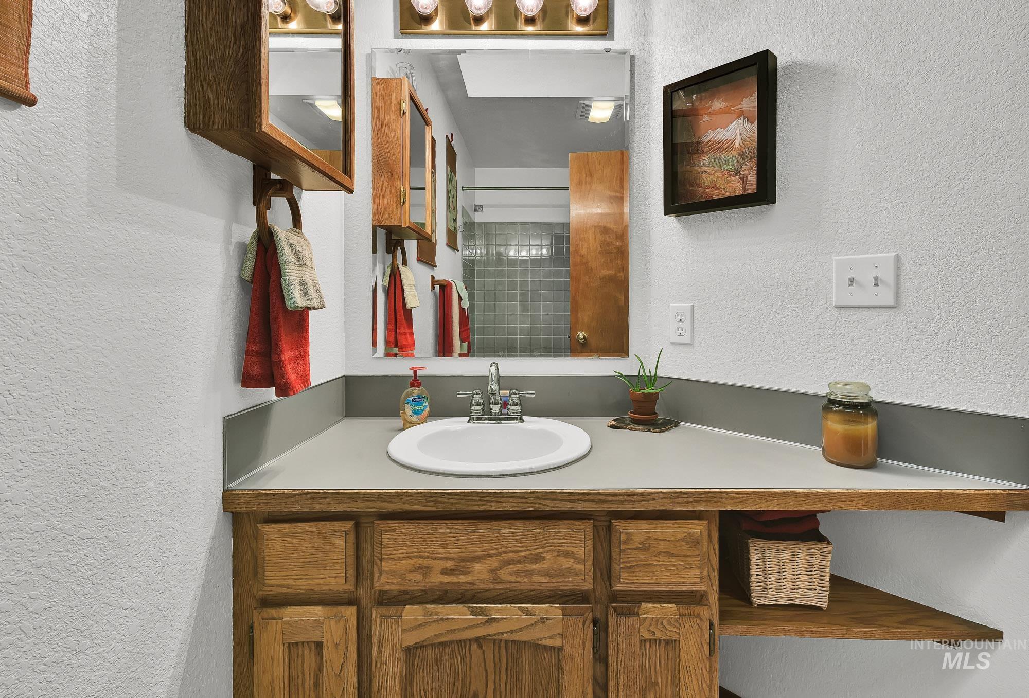 Bathroom featuring a textured wall and vanity