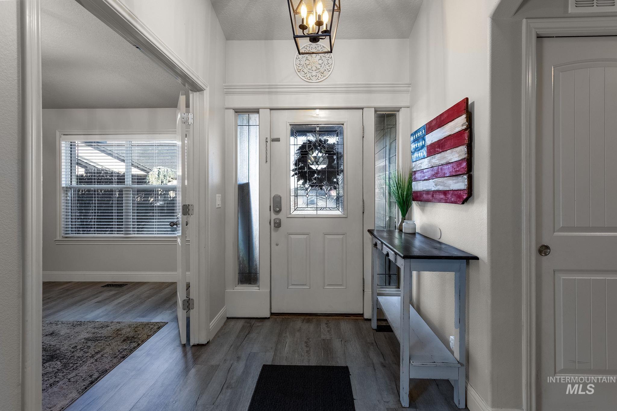 Entryway featuring wood finished floors and a chandelier