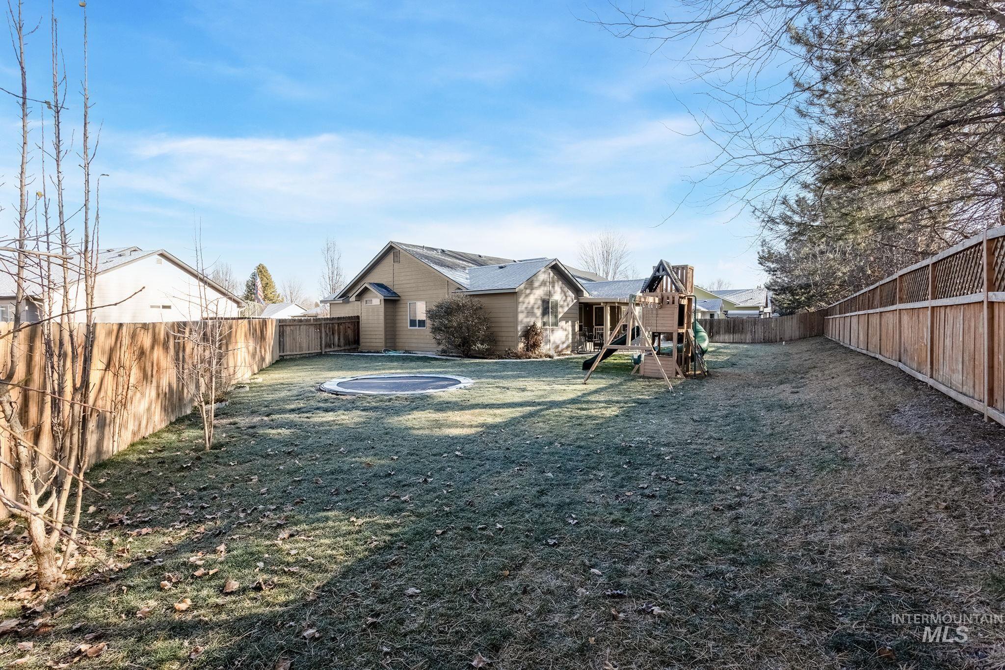 Fenced backyard featuring a playground