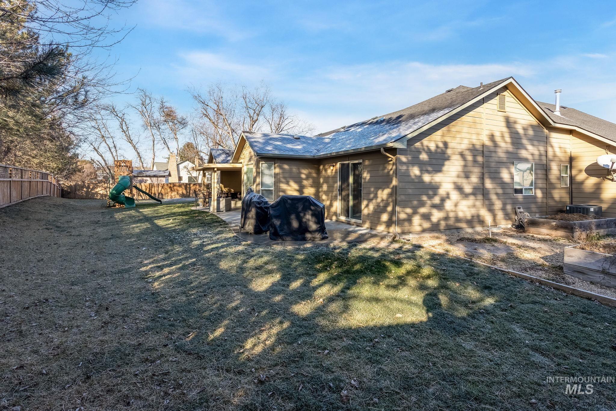 Back of property with a fenced backyard, a patio, and a playground